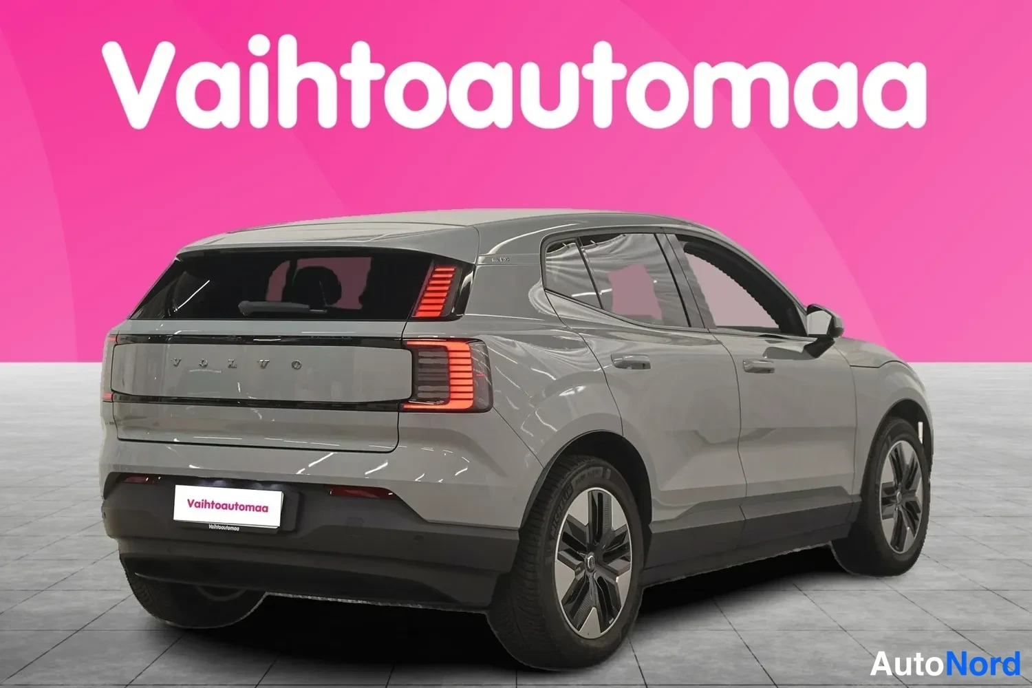 Takaviisto: Auton takaosan kolmeneljänneskuva: peräkansi, pystysuorat takavalot ja vasen kylki harmaassa autossa.