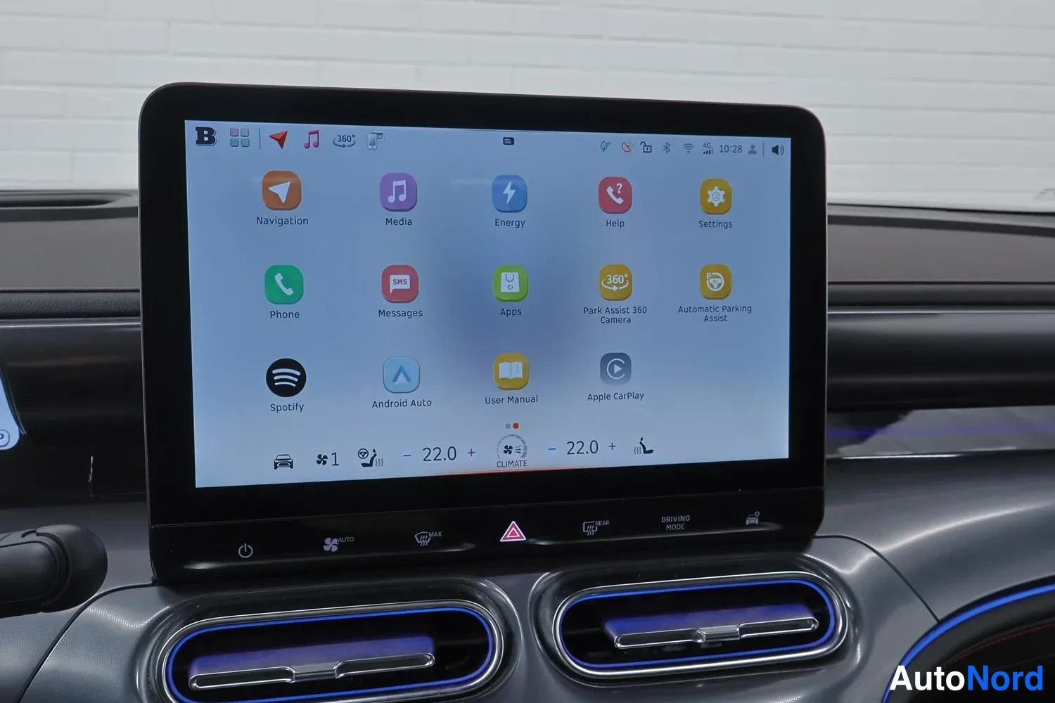 Yksityiskohta: Keskinäytön valikko jossa sovelluskuvakkeet: Navigation, Media, Energy, Phone, Spotify, Android Auto ja Apple CarPlay. Ilmastointi näkyy 22,0 asteen asetuksella