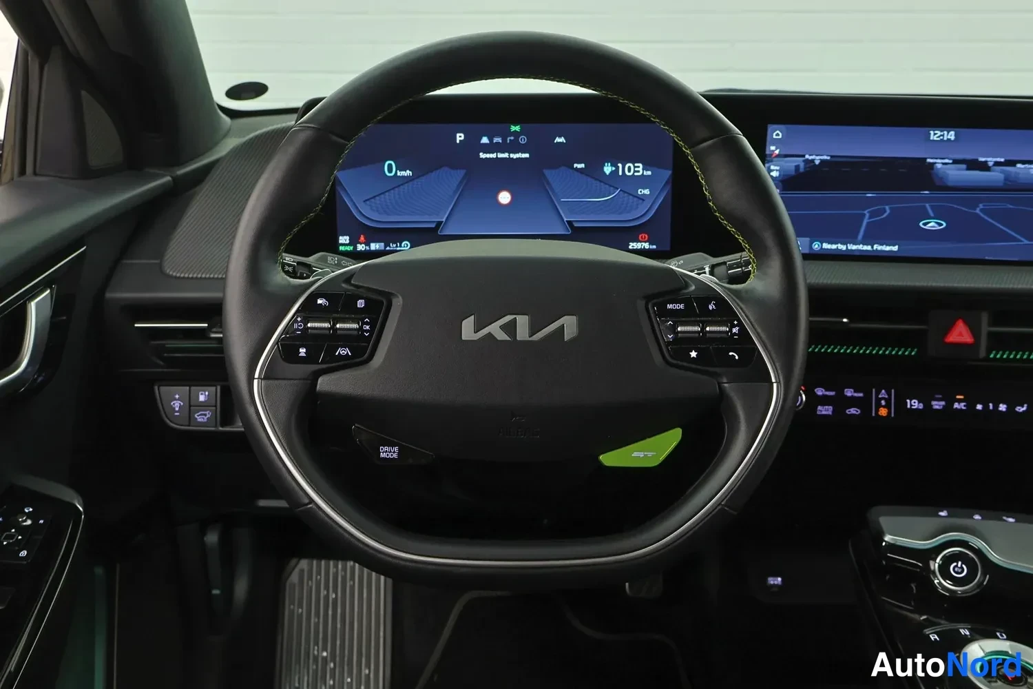 Yksityiskohta: Lähikuva Kia-ohjauspyörästä ja mittaristonäytöstä, joka näyttää 0 km/h ja 103 km toimintamatkaa.