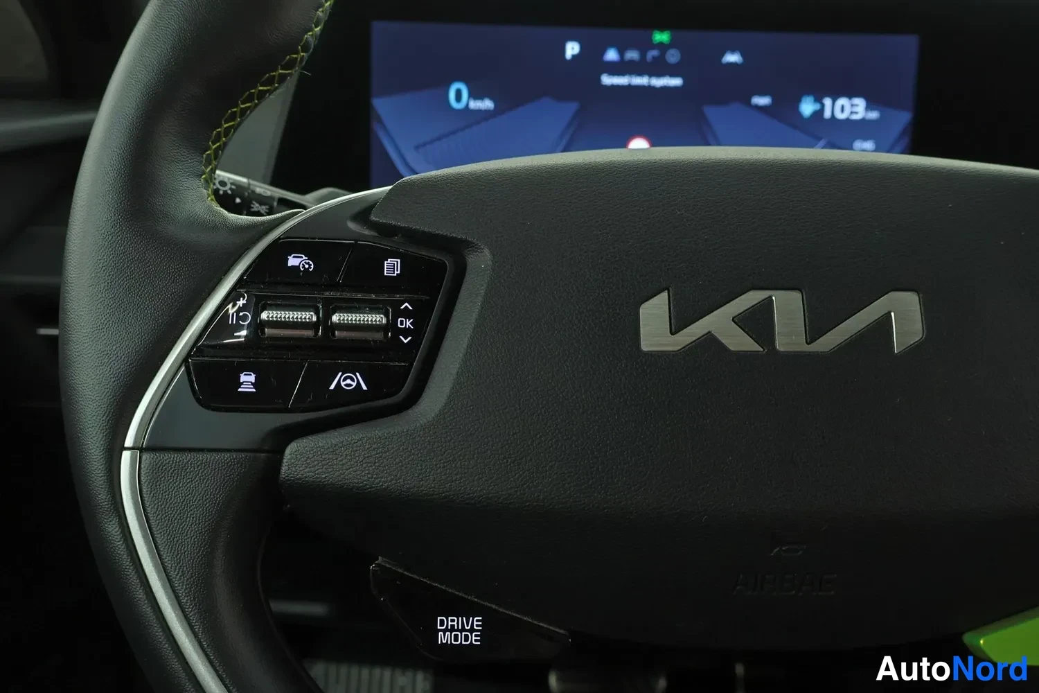 Muu: Sisäkuva: Kia-ohjauspyörän vasen painikeryhmä ja mittariston näyttö, jossa näkyy 0 km/h, P ja 103 km toimintamatka.