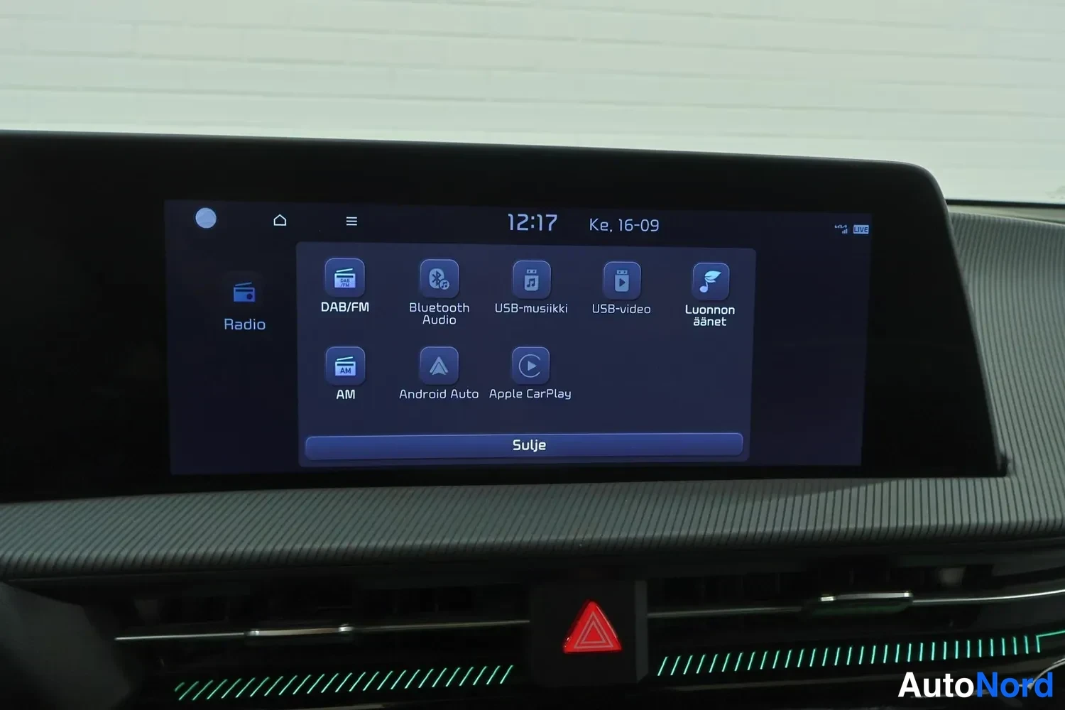 Ohjaamo: Infotainment-järjestelmän päävalikko. Ikoneissa 'Radio', 'DAB/FM', 'Bluetooth Audio', 'USB-musiikki', 'USB-video', 'Luonnon änet', 'AM', 'Android Auto' ja 'Appl