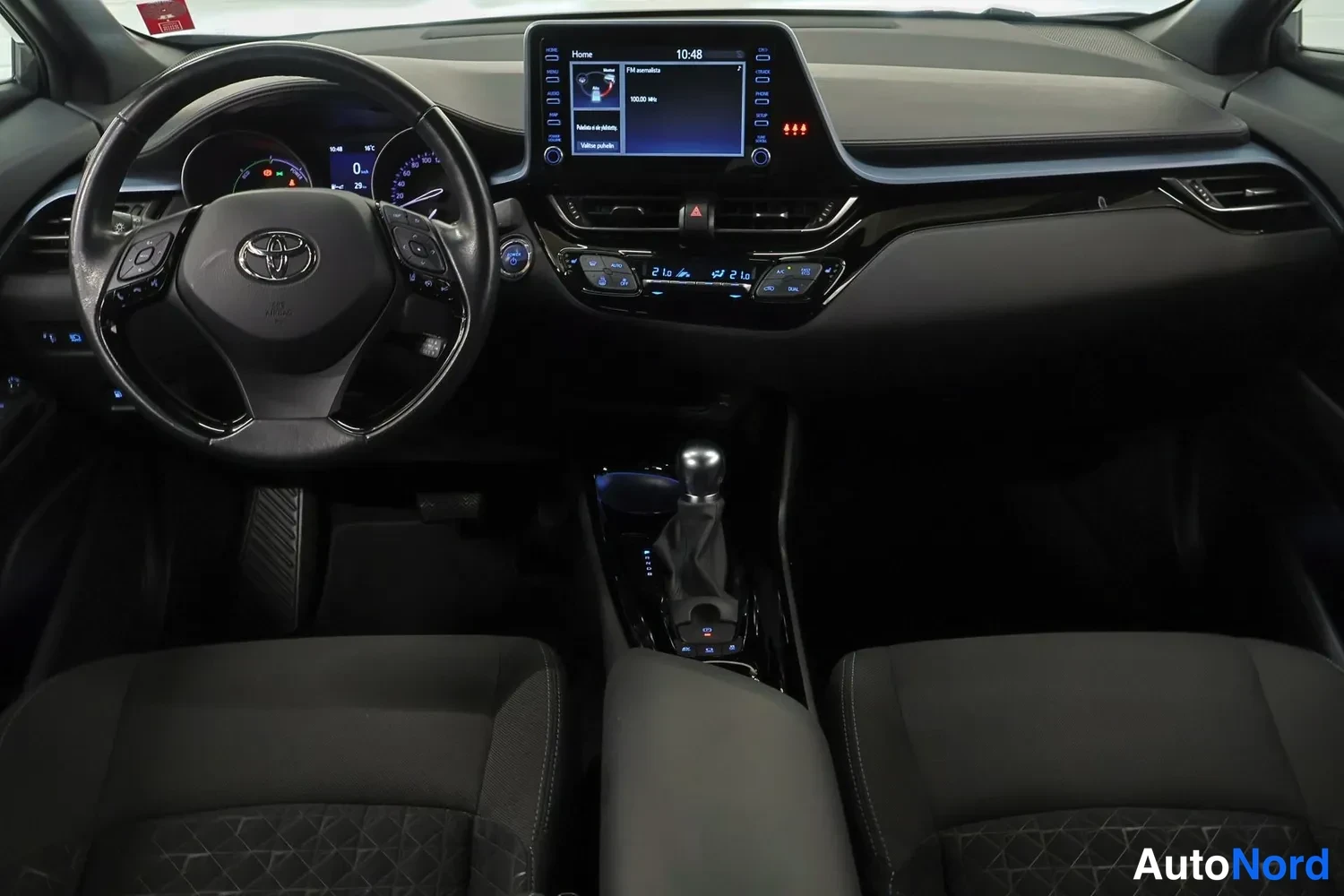 Muu: Ohjaamo etusisäkuva: Toyota-ohjauspyörä, mittaristo ja infotainment-näyttö näkyvät keskikonsolilla.