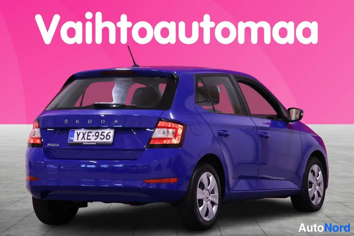 Takaviisto: Sininen henkilöauto takaa kolmesta neljäksestä kuvattuna, rekisteritunnus, ŠKODA-teksti ja FABIA-merkintä takaluukussa.
