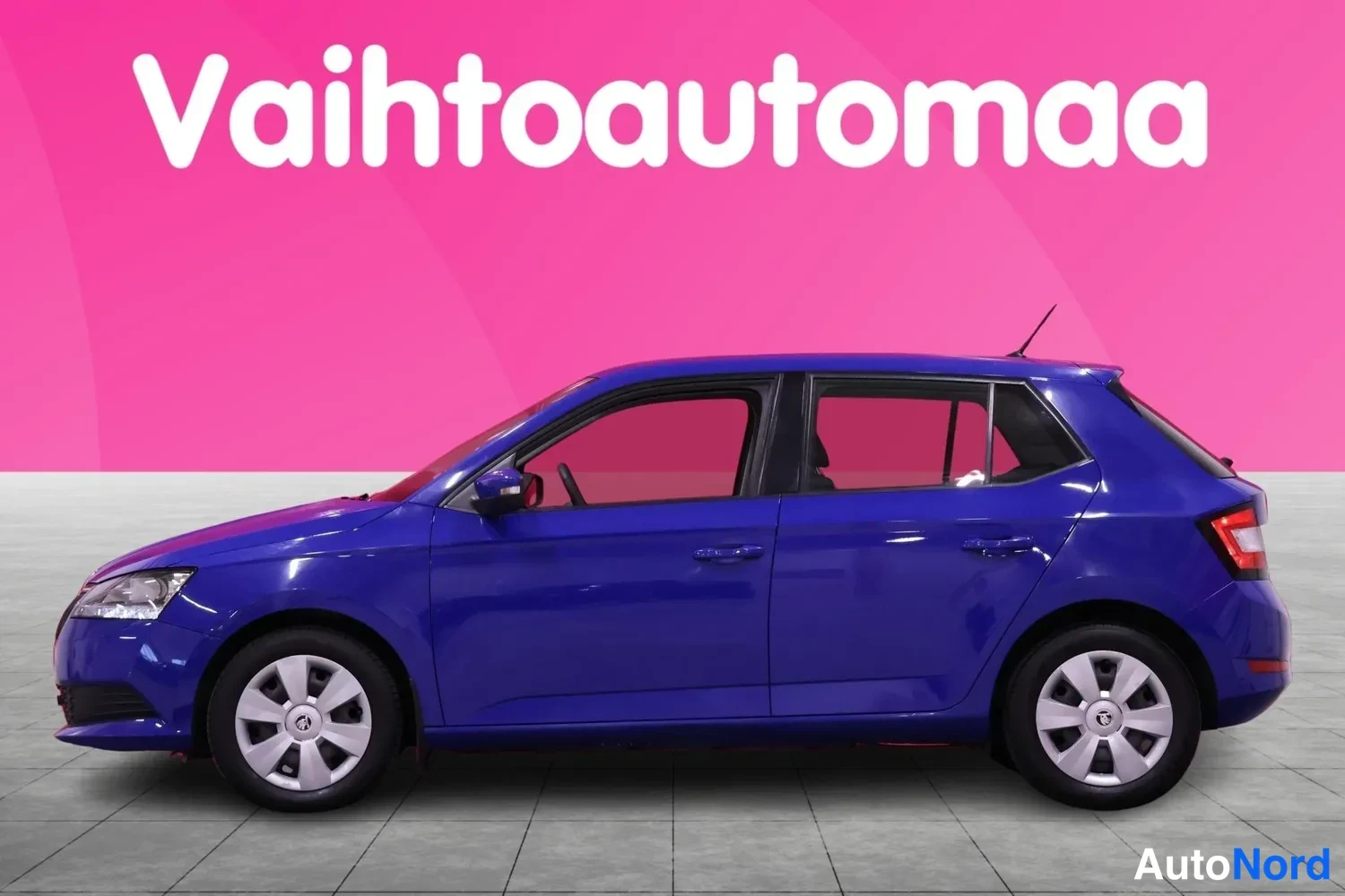 Etuviisto, nokka vasemmalle: Sininen Skoda Fabia kyljestä hieman keulasta kuvattuna, keula vasemmalla.