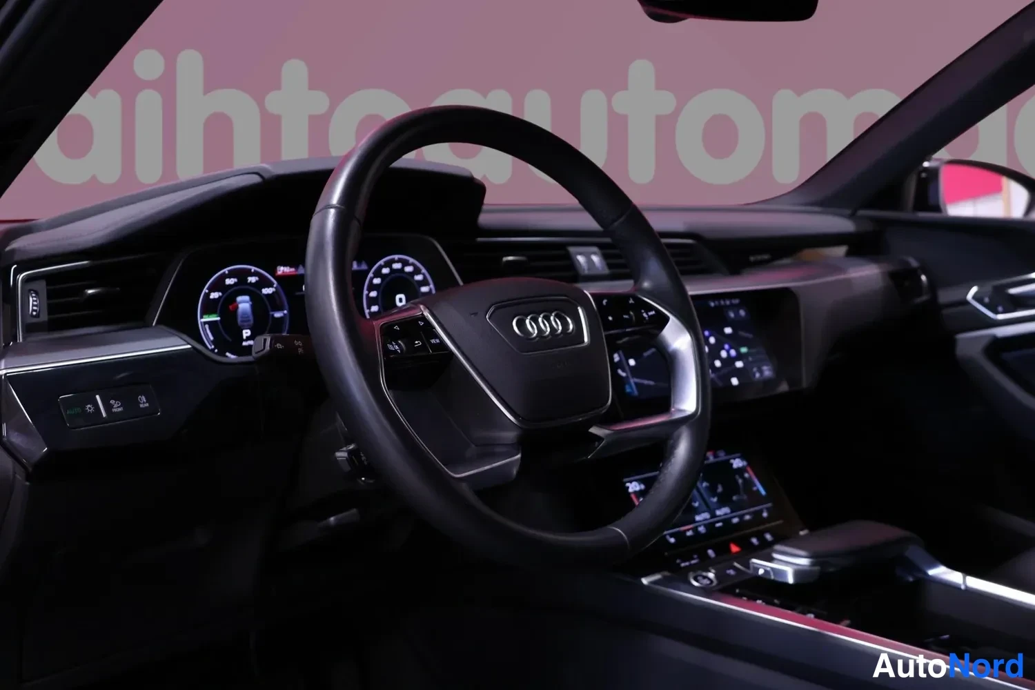 Yksityiskohta: Ohjaamon etunakyma: Audi-merkkinen monitoimiohjauspyora, digitaalinen mittaristo ja keskikonsolin kosketusnaytto.