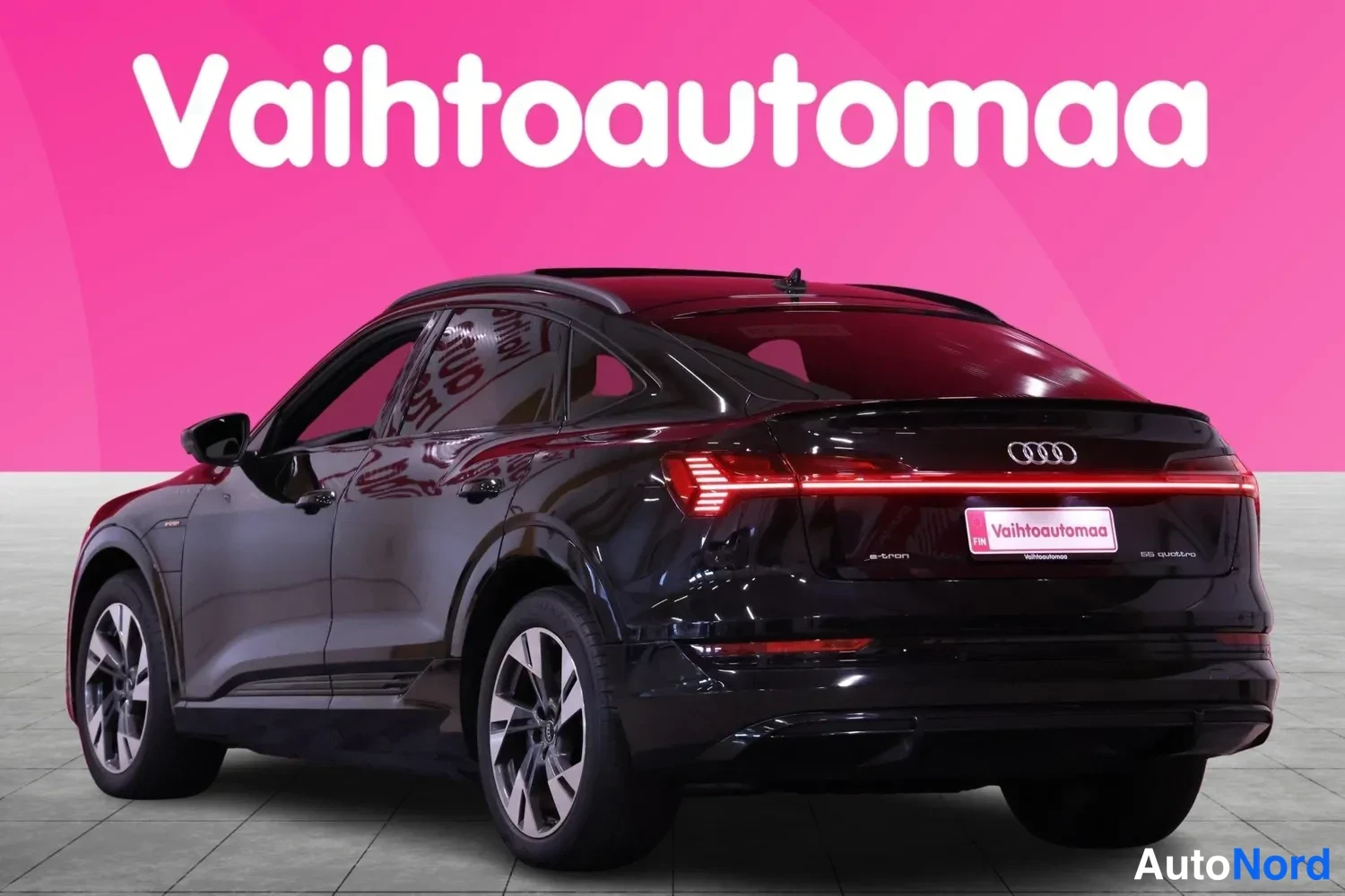 Takaviisto: Mustan tila-auto-katumaasturin takakulma: valojen pitkä ohut takajalka syttyy, peräluukussa merkki e-tron.