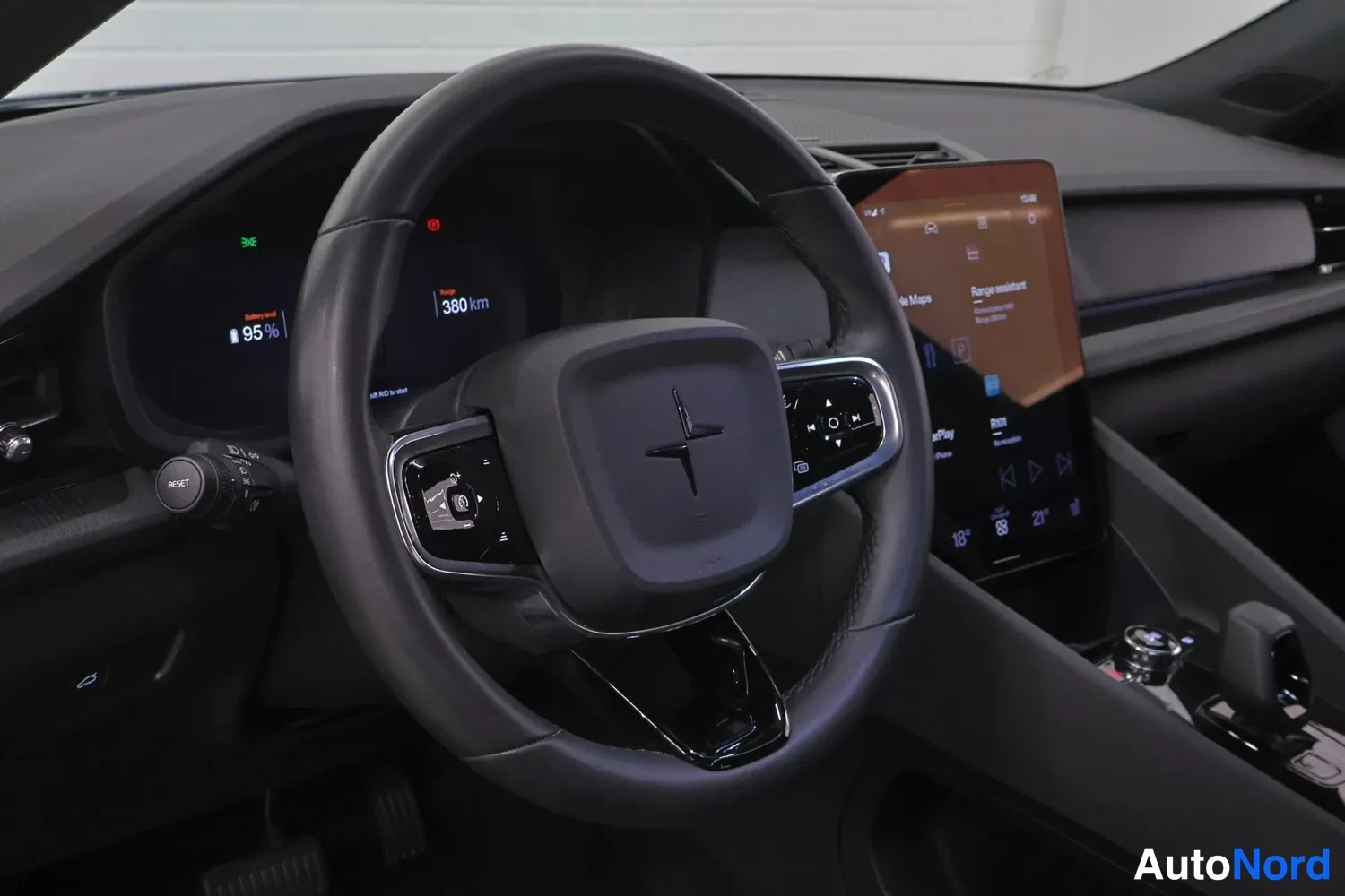 Etuviisto, nokka oikealle: Polestar-ohjauspyörä, mittaristo näyttää 380 km ja 95 %, keskinäytöllä sovelluksia kuten Google Maps ja Apple CarPlay.