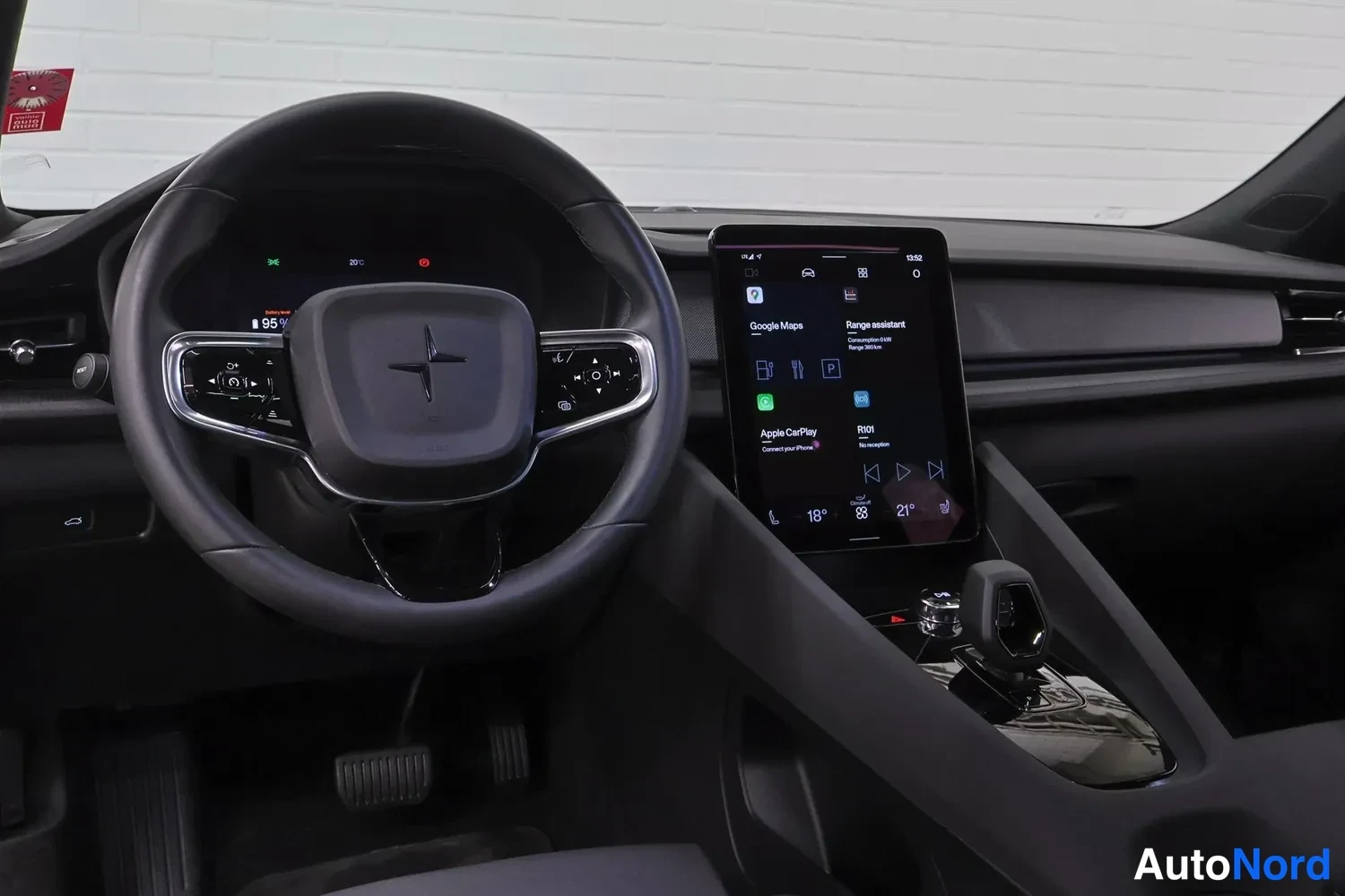 Muu: Kuljettajan puolen dashboard: ohjauspyörä, digitaalinen mittaristo ja pystysuora keskusnäyttö, jossa Google Maps, Apple CarPlay ja Range assistant -valikot; näy