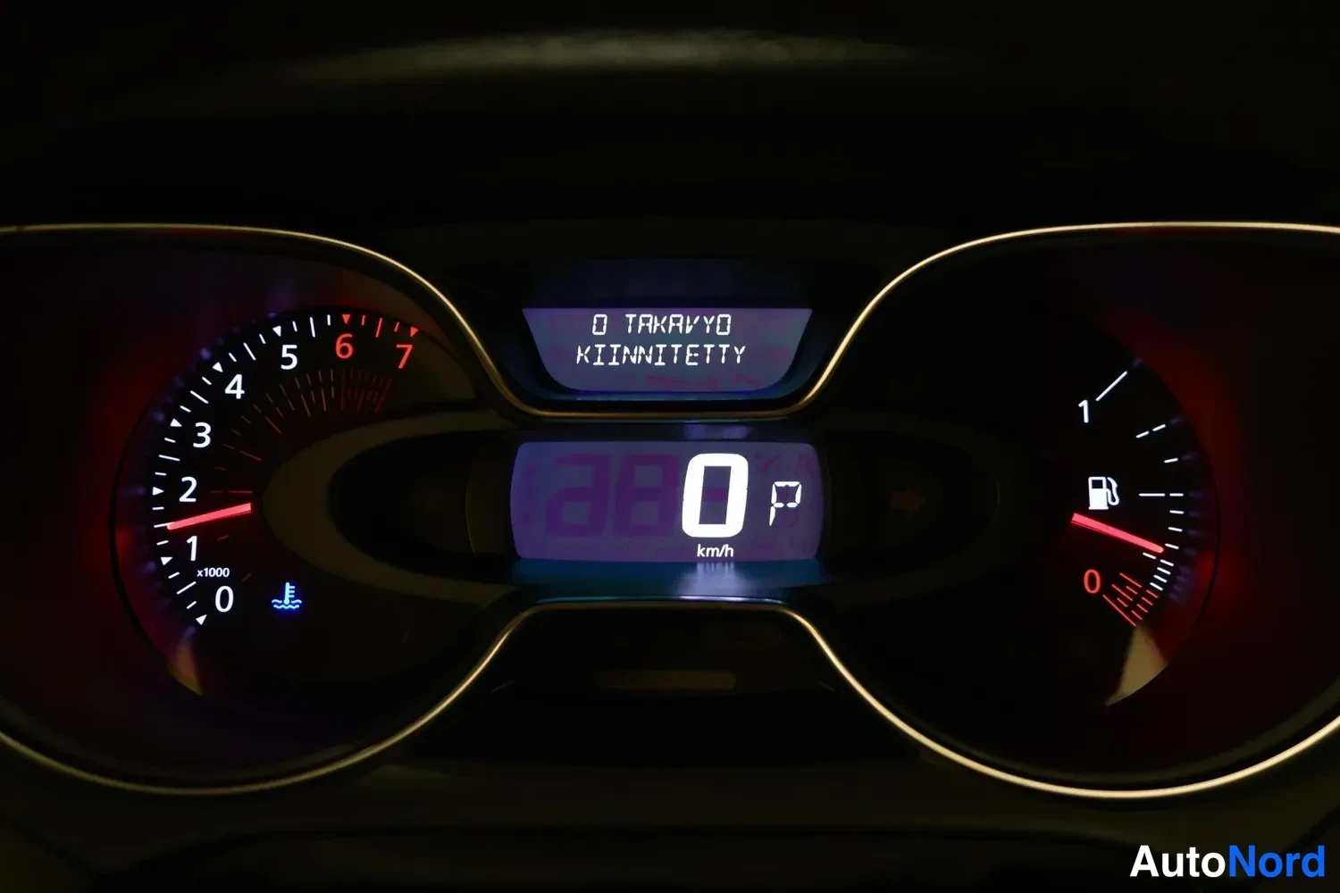 Muu: Mittaristo lähikuvassa: nopeus 0 km/h, vaihde P ja teksti 'O TAKAYO KIINNITETTY'.