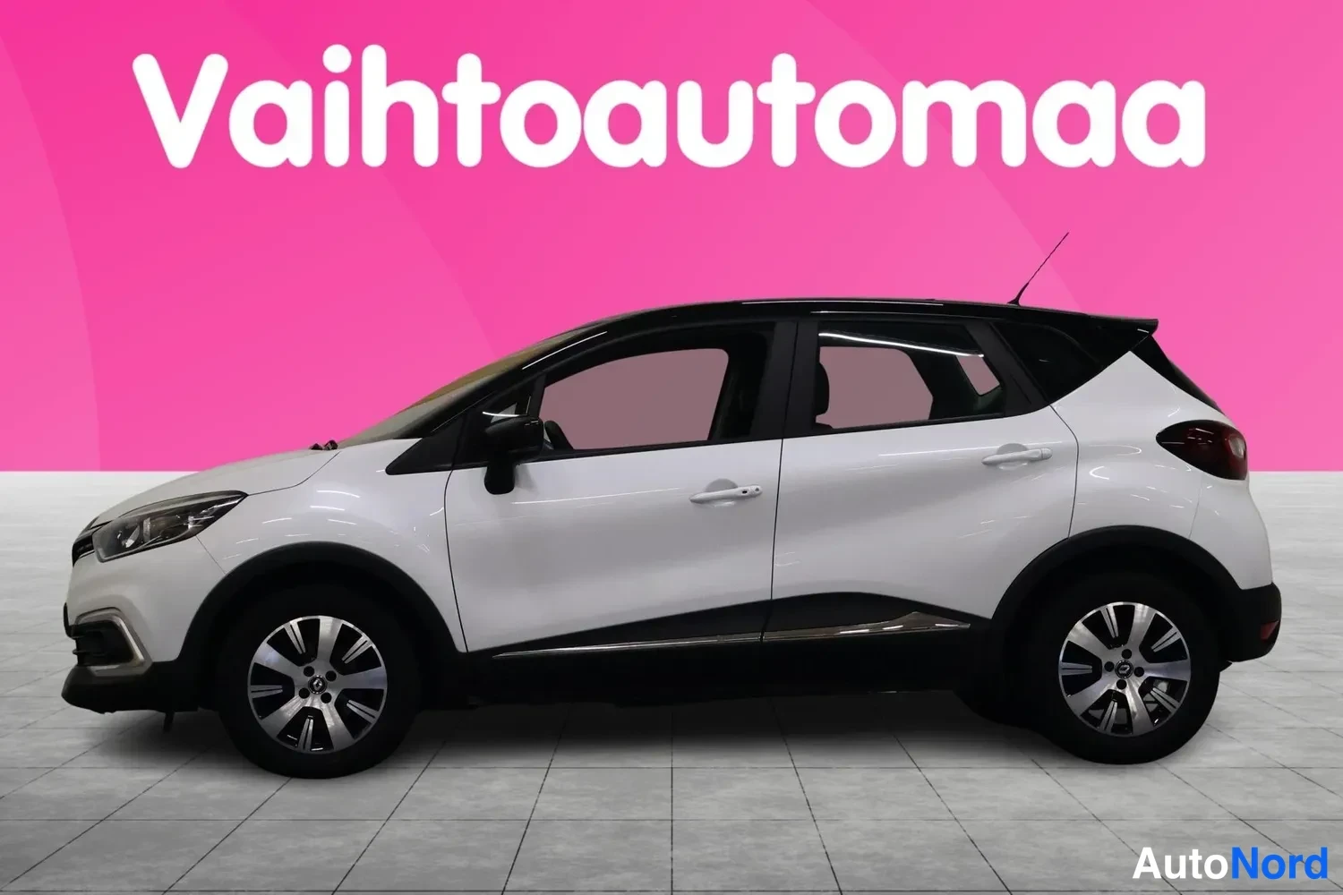Etuviisto, nokka vasemmalle: Valkoinen Renault Captur kulmauksesta edestä vasemmalta, musta katto ja peilit.