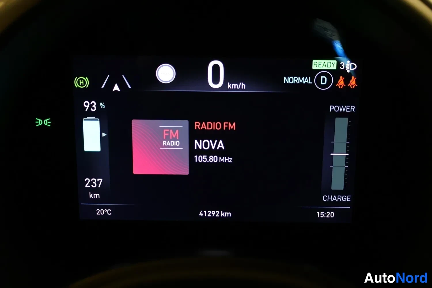 Muu: Kojelaudan näyttö: 0 km/h, akku 93 %, toimintasäde 237 km, kokonaislukema 41292 km, RADIO FM NOVA 105.80 MHz, READY-merkki.