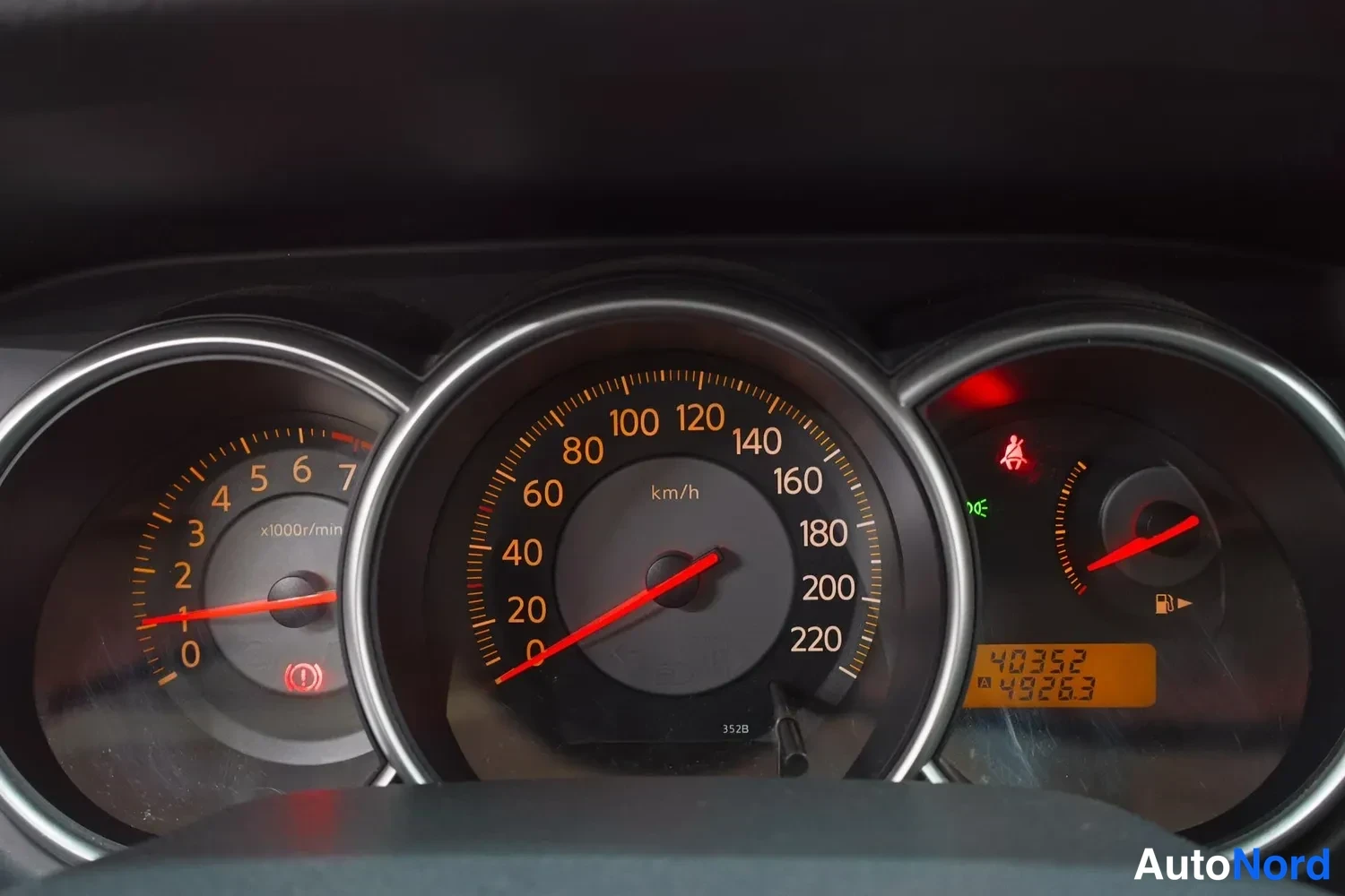 Yksityiskohta: Mittaristo: nopeusmittari asteikolla 0–220 km/h, kierrosmittari ja matkamittari lukemassa 49263