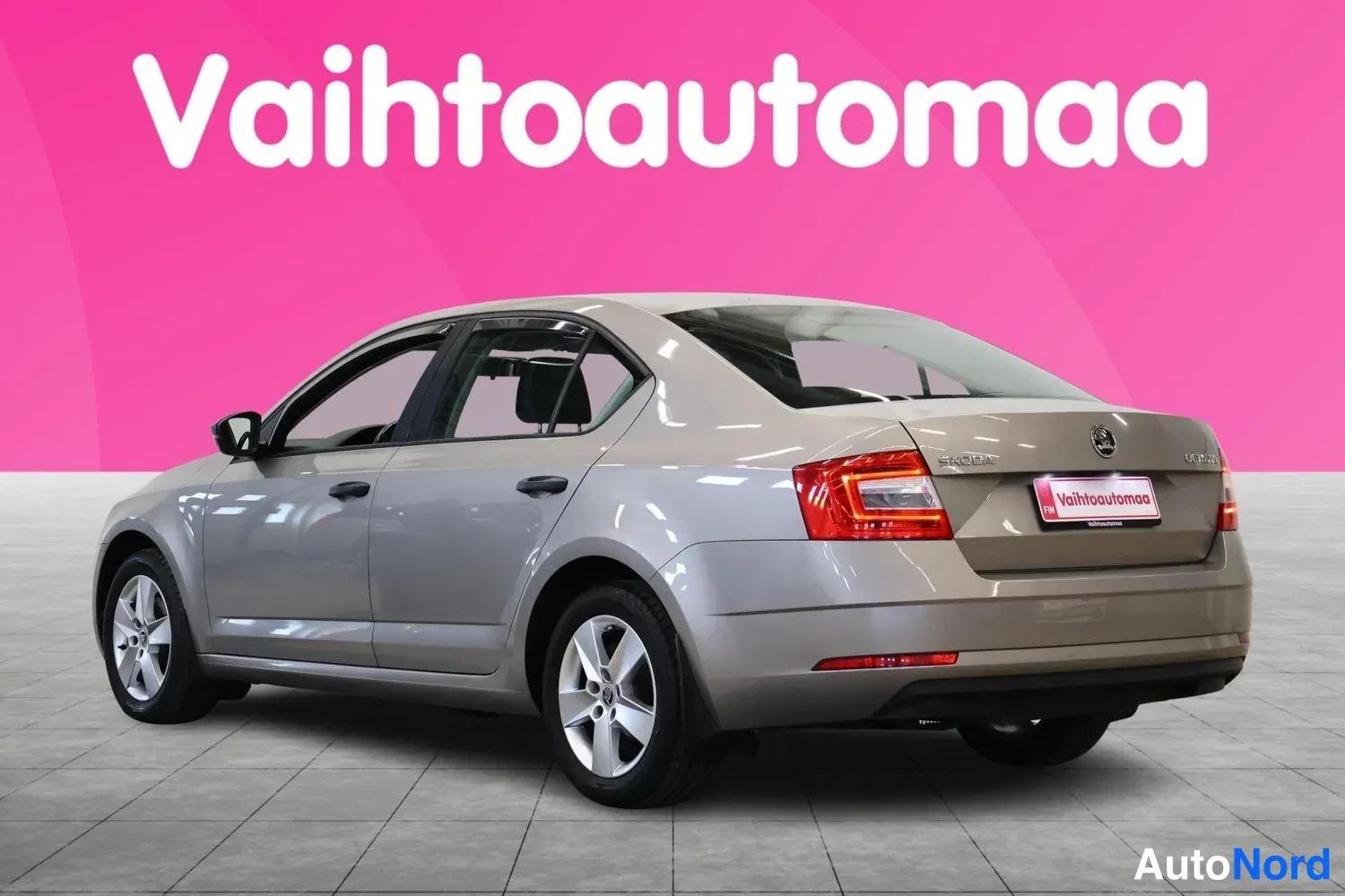 Takaviisto: Skoda Octavia -sedanin takakulma vasemmalta, punaiset takavalot ja Vahtoautomaa-kyltti rekisterikilven paikalla.