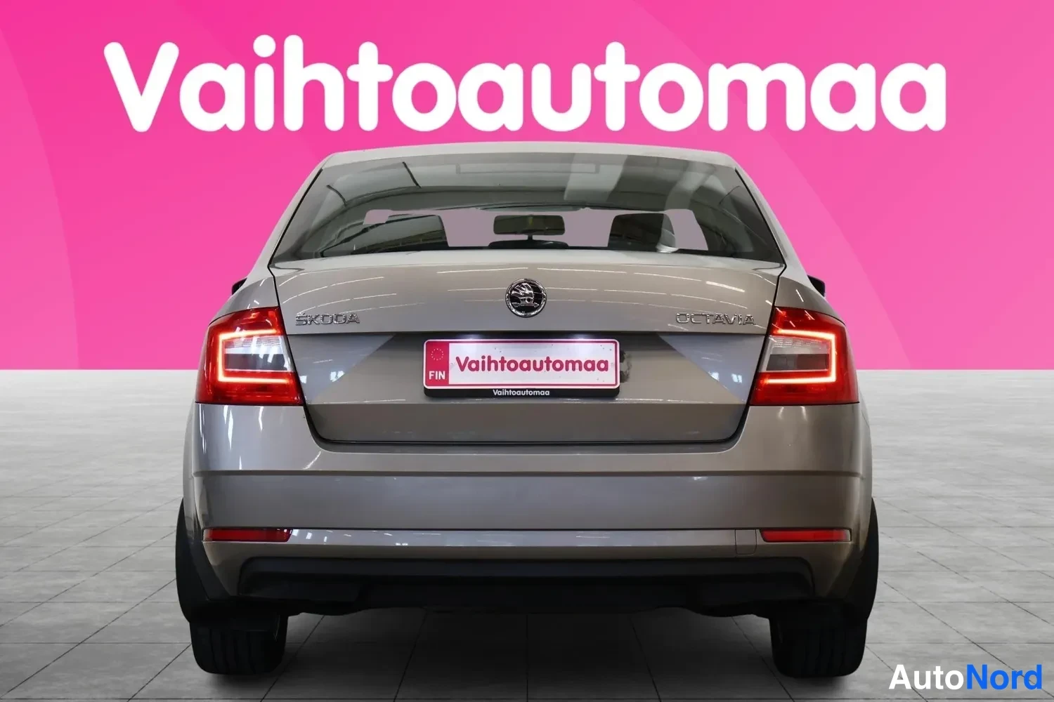 Takaa: Skoda Octavian takaosa suoraan takaa, peräluukussa OCTAVIA-teksti ja Vahtoautomaa-tunnuksellinen rekisterikilpi.