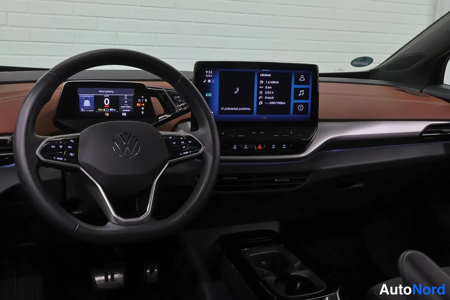 Yksityiskohta: VW-ohjauspyörä, digitaalinen mittaristo ja keskikosketusnäyttö, ruskea tumma mittaripaneeli.
