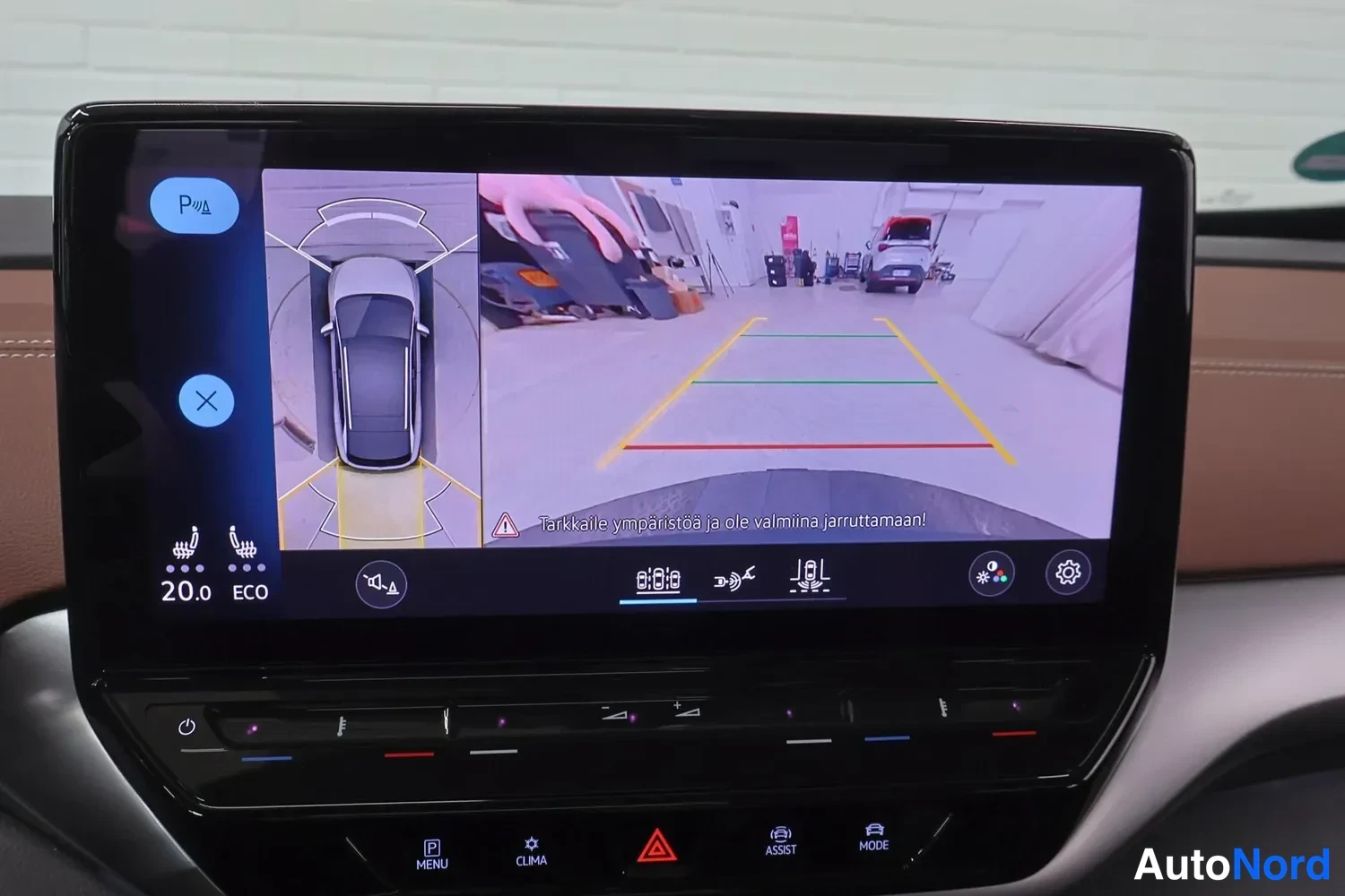 Muu: Keskikonsolin infotainment-näyttö näyttää peruutuskameran kuvan ja 360-tyyppisen kattavan auto-sivunapin; varoitus 'Tarkkaile ympäristöä ja ole valmiina jarrutt