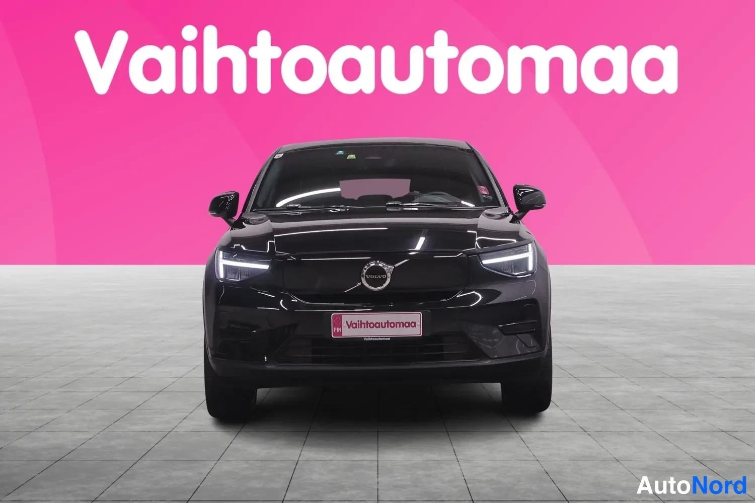 Edestä: Musta Volvo-henkilöauto suoraan edestä, etusäleikkö ja Volvon merkki näkyvät.