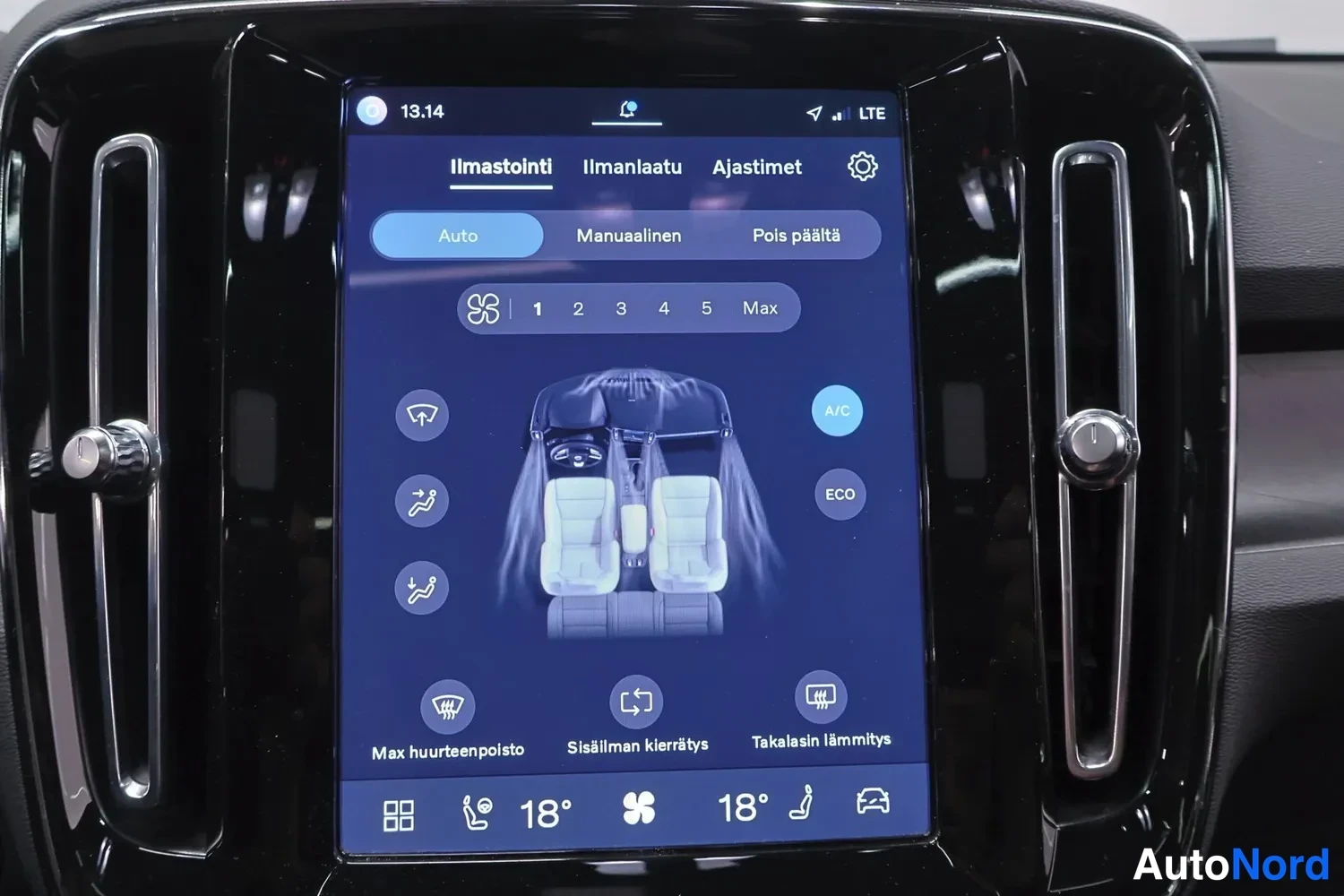 Yksityiskohta: Close-up of the Volvo's vertical touchscreen display, showing climate control options in Finnish: Ilmastointi (Ventilation), Auto/Auto mode selected, temperatur