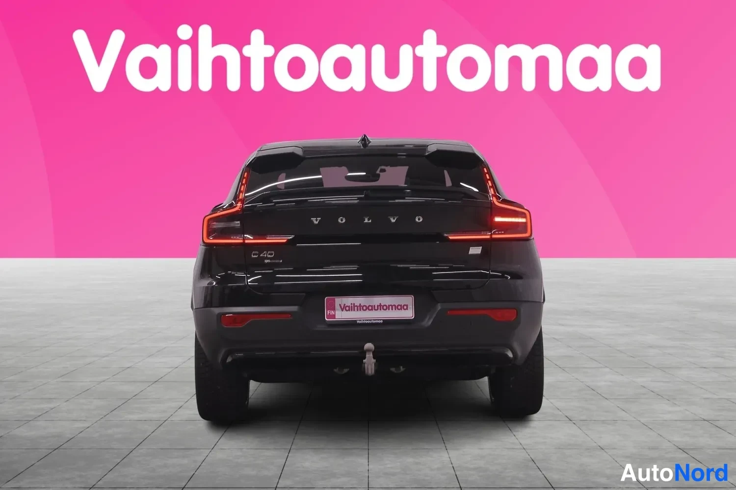 Takaa: Mustan henkilöauton suora takanäkymä, takavalaistus ja VOLVO-teksti takaoven kannessa.