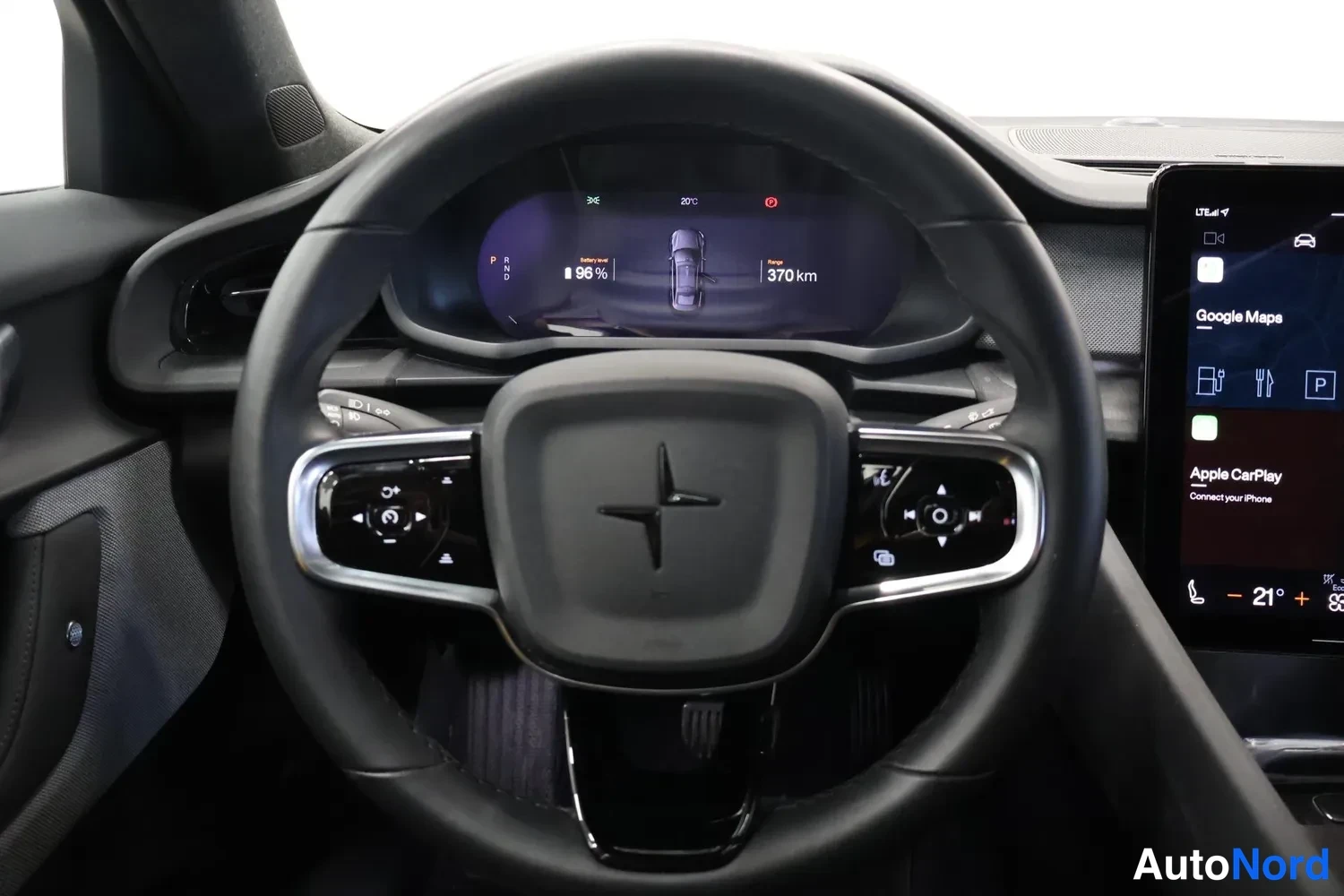 Muu: Ohjauspyörä ja mittaristo lähikuvassa, näytöllä lukemat 96 % ja 370 km; oikealla infotainment-näytön reuna Google Maps ja Apple CarPlay -teksteillä.
