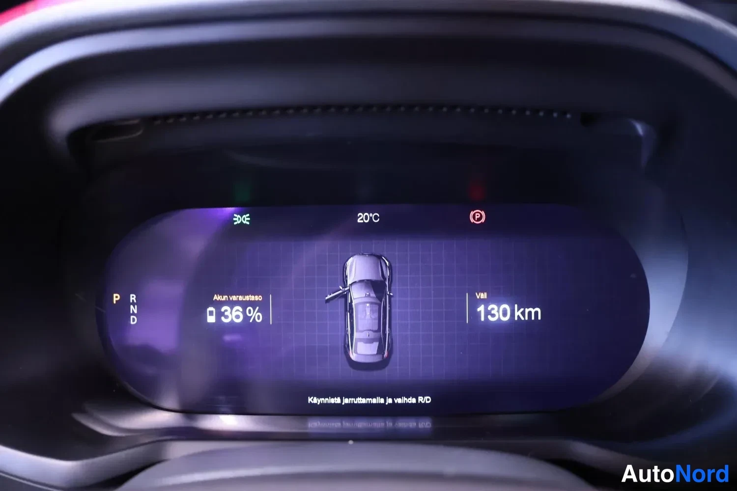 Muu: Digitaalinen mittaristo lähikuvassa: Akun varausaste 36 %, Välj 130 km, P-vaihde valittuna, ulkolämpötila 20 °C ja ohje 'Käynnistä jaruttamalla ja valitse R/D'.