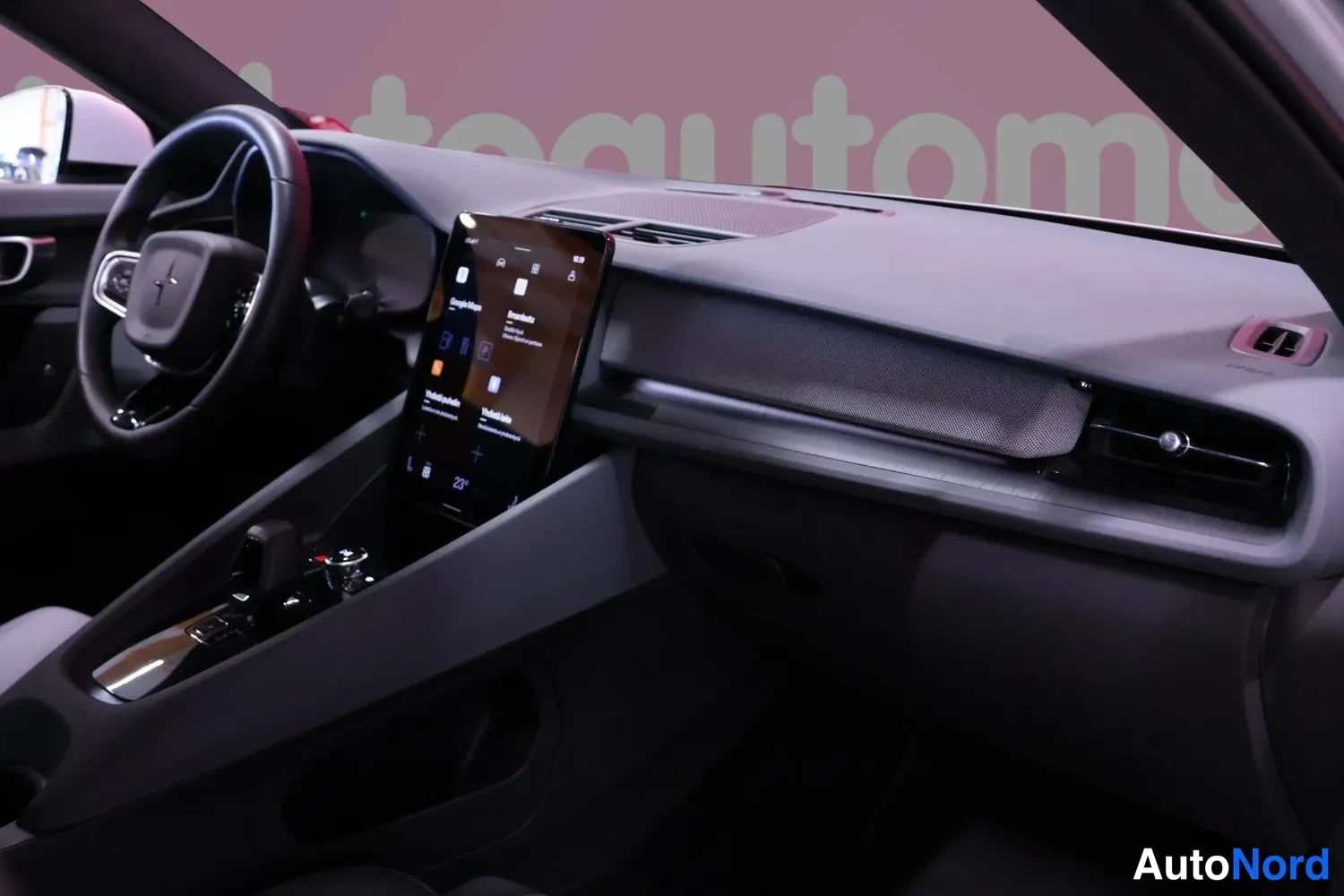 Ohjaamo: A wide view of the cabin dashboard featuring a vertical infotainment display in the center console, a multifunction steering wheel, and front vents.