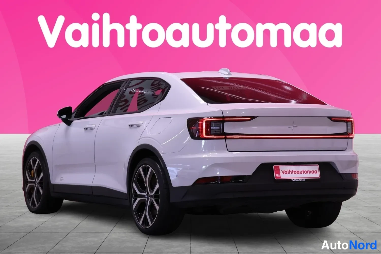 Takaviisto: Auton takanurkkaus vasemmalta: vaaleanpunainen tausta, takavalot ja perä näkyvät, rekisteripaikassa Vahtoautomaa-tarra.