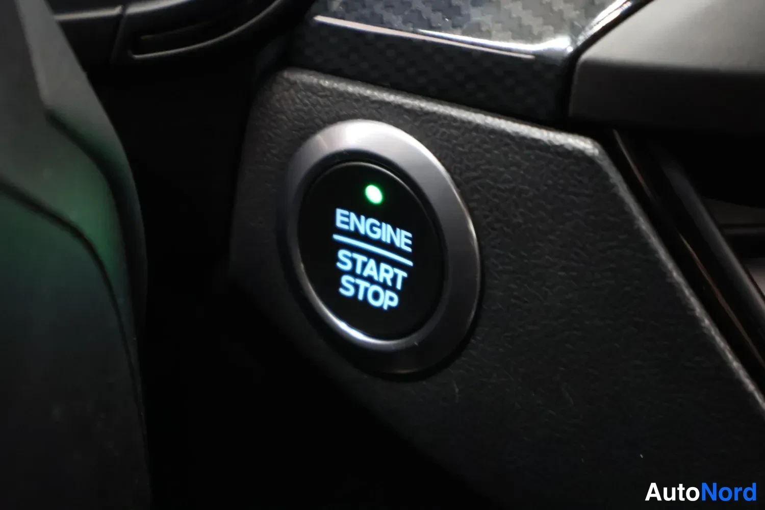 Muu: Sisäkuva: keskiratkaisimen ENGINE START STOP -painike, jossa vihreä merkkivalo palaa.