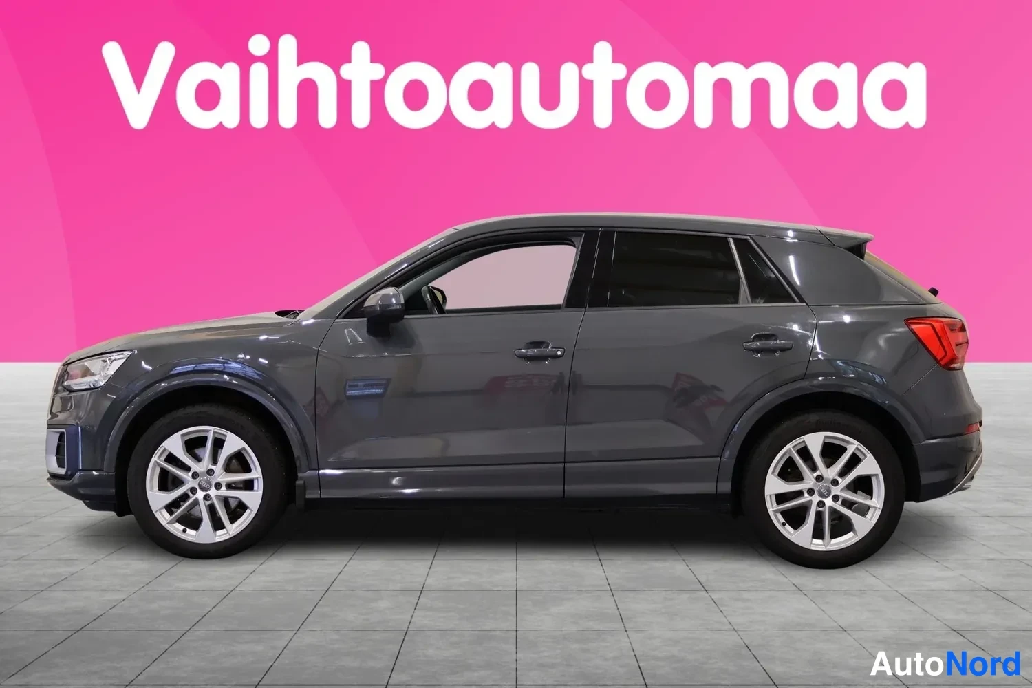Sivulta: Audi Q2 sivulta, tummanharmaa korimalli pinkilla taustalla.