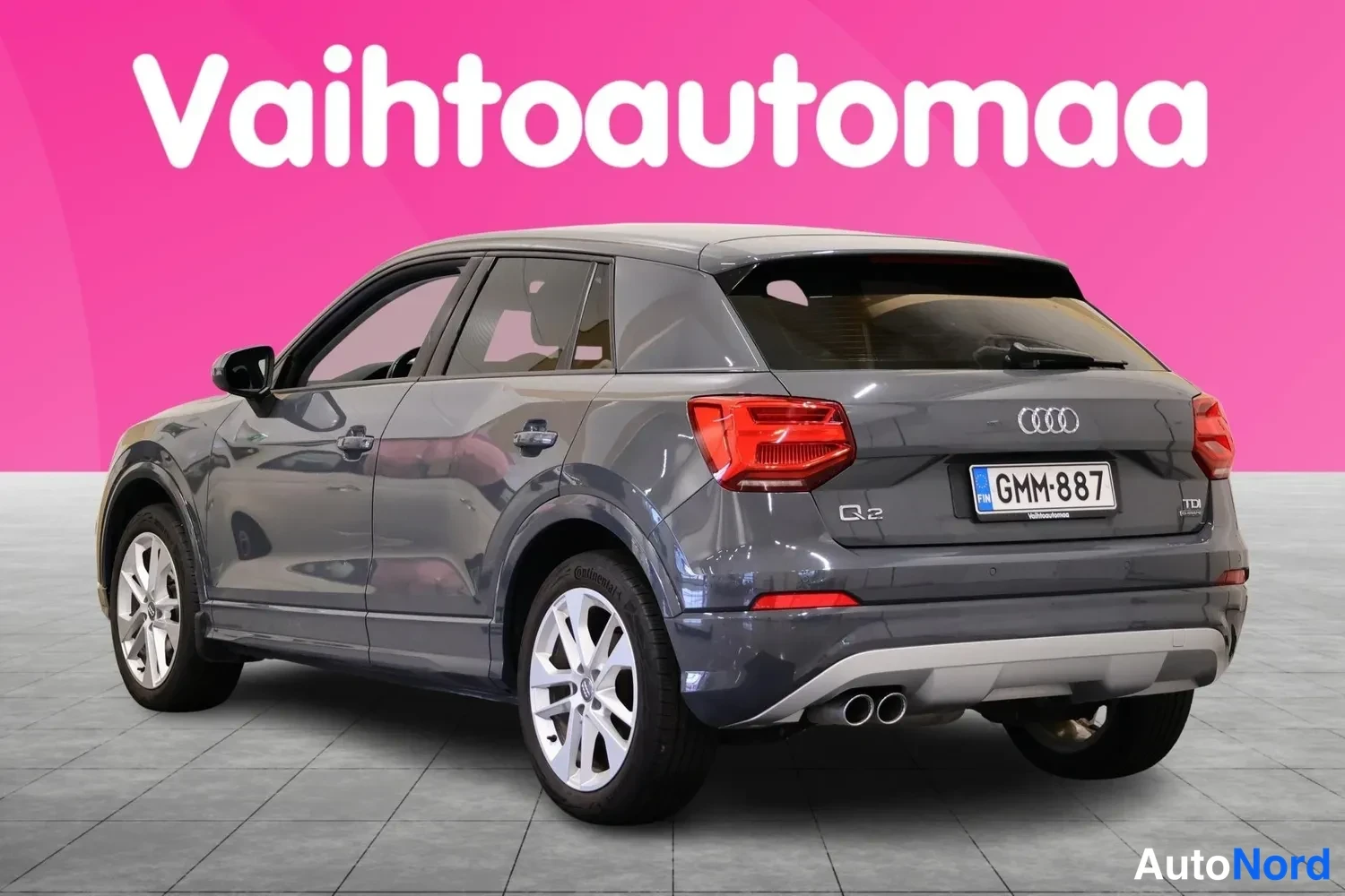 Takaviisto: Audi Q2 takakulmasta, tummanharmaa korimalli, rekisteritunnus, kaksoispakoputki näkyvissä.