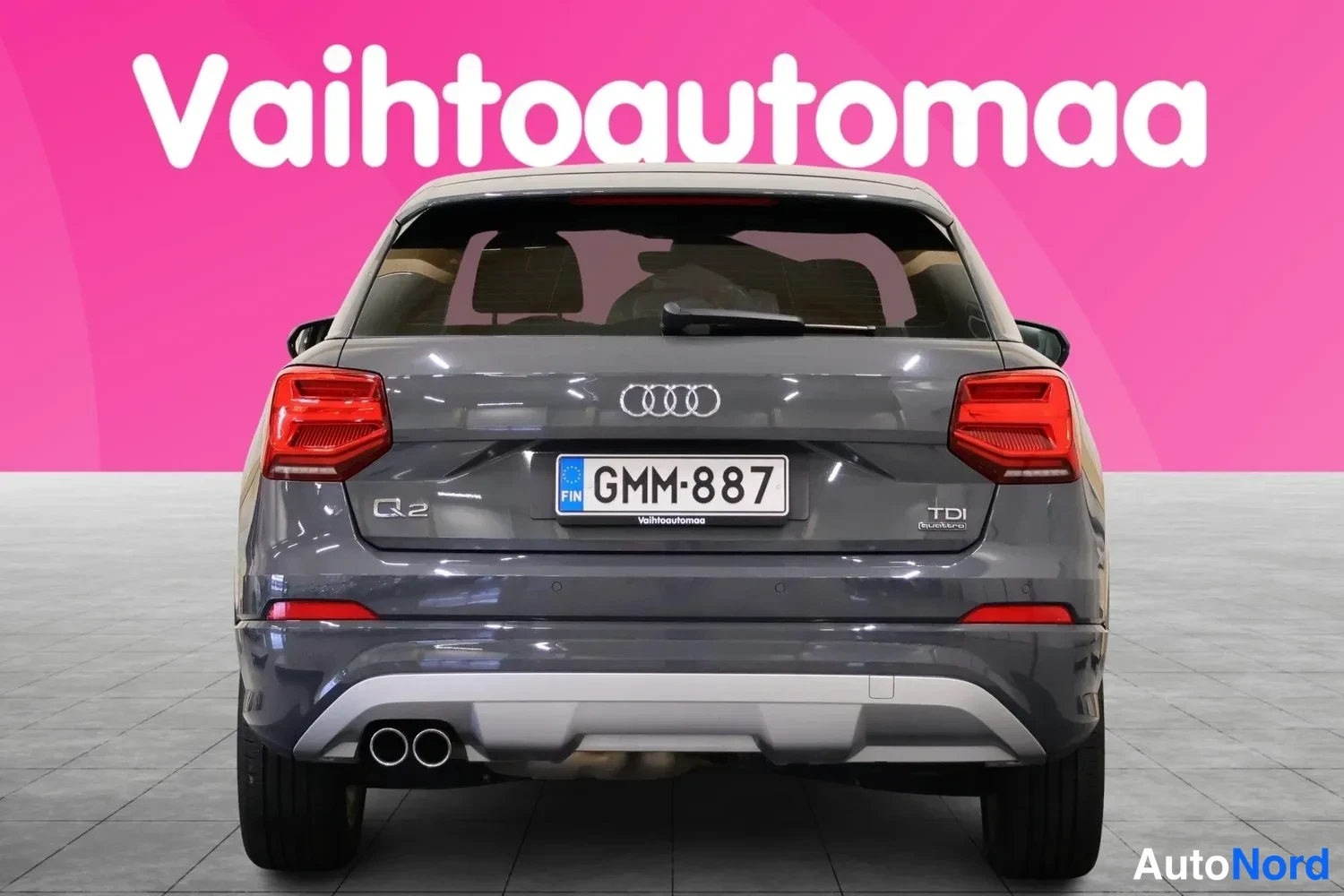 Takaa: Audi Q2 suoraan takaa, tummanharmaa korimalli, rekisteritunnus, TDI-merkintä näkyvissä.