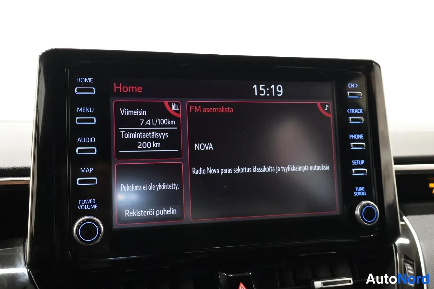 Muu: Auton kosketusnäytöllä näkyy Home-valikko kello 15:19, viimeisin kulutus 7,4 L/100km, toimintaetäisyys 200 km, FM-asemalistassa radioasema NOVA sekä viestit 'Pu
