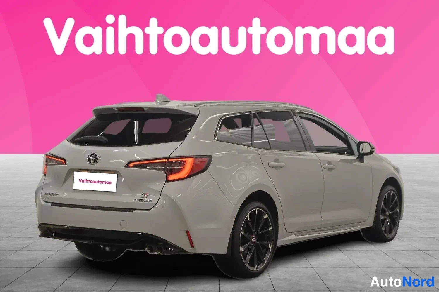 Takaviisto: Auton takaosa ja vasen sivu kolmannelta kulmalta; vaaleanharmaa farmarikorinen auto tummilla vanteilla.