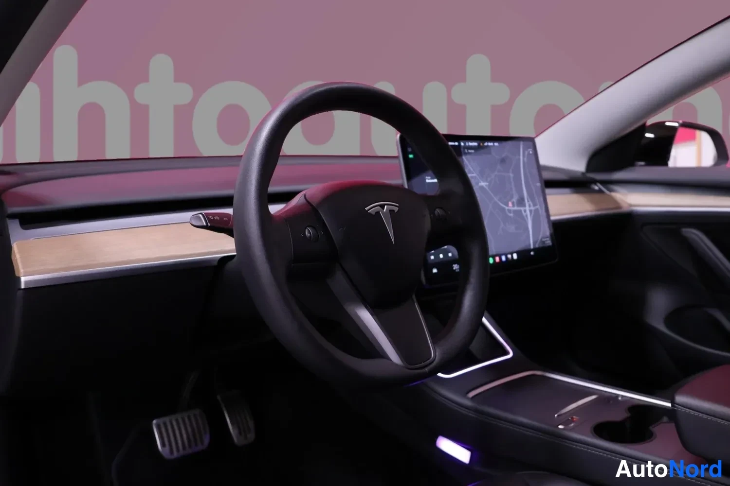 Edestä: Tesla-ohjauspyörä ja keskiruutu, jolla näkyy karttanäkymä.