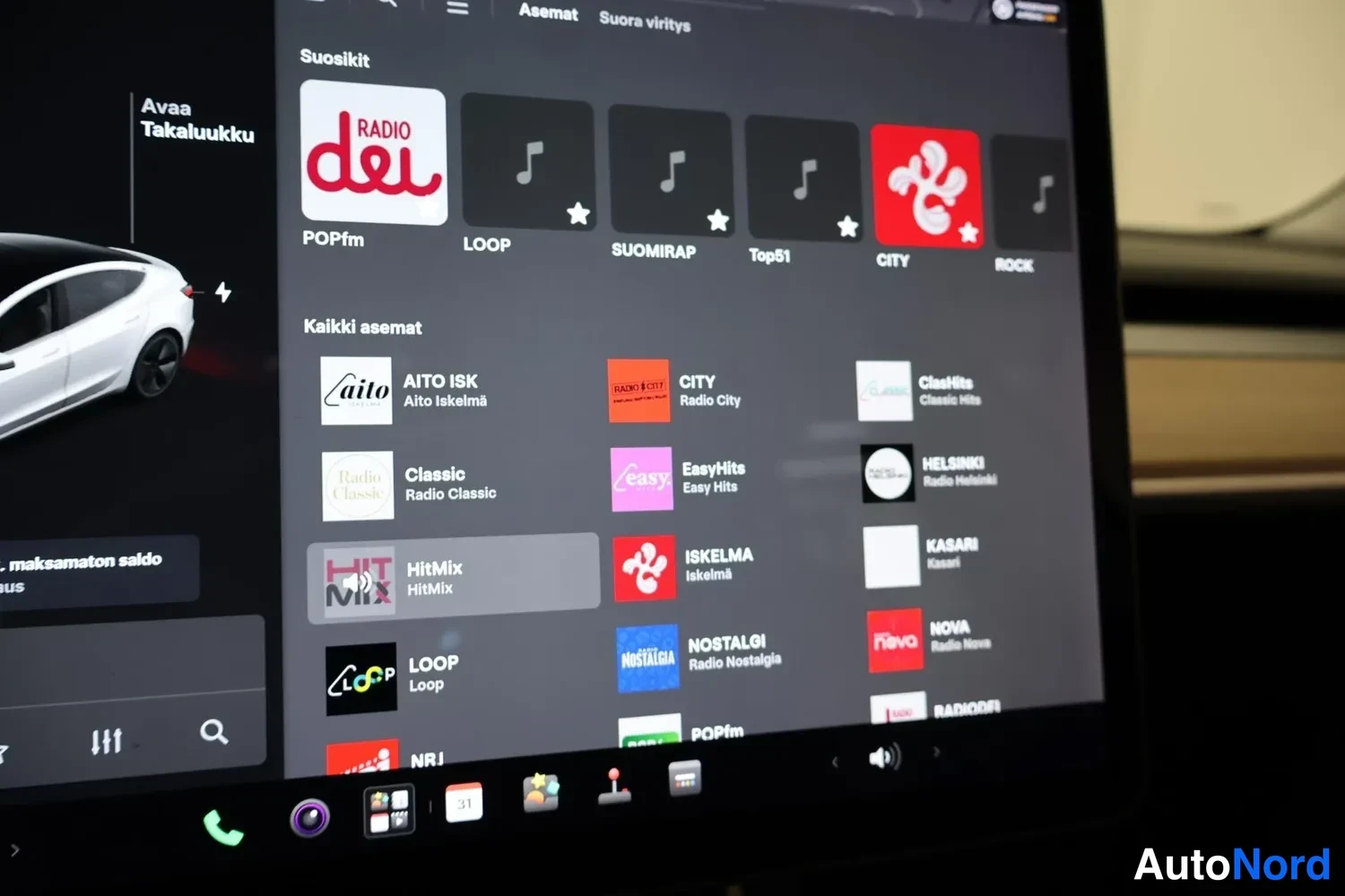 Muu: Tesla Model 3:n medianäkymä näytöllä: radioasemaluettelo, suosikit kuten RADIO dei POPfm, CITY ja ROCK, kaikki asemat listattuna (AITO ISK, Classic, EasyHits, H