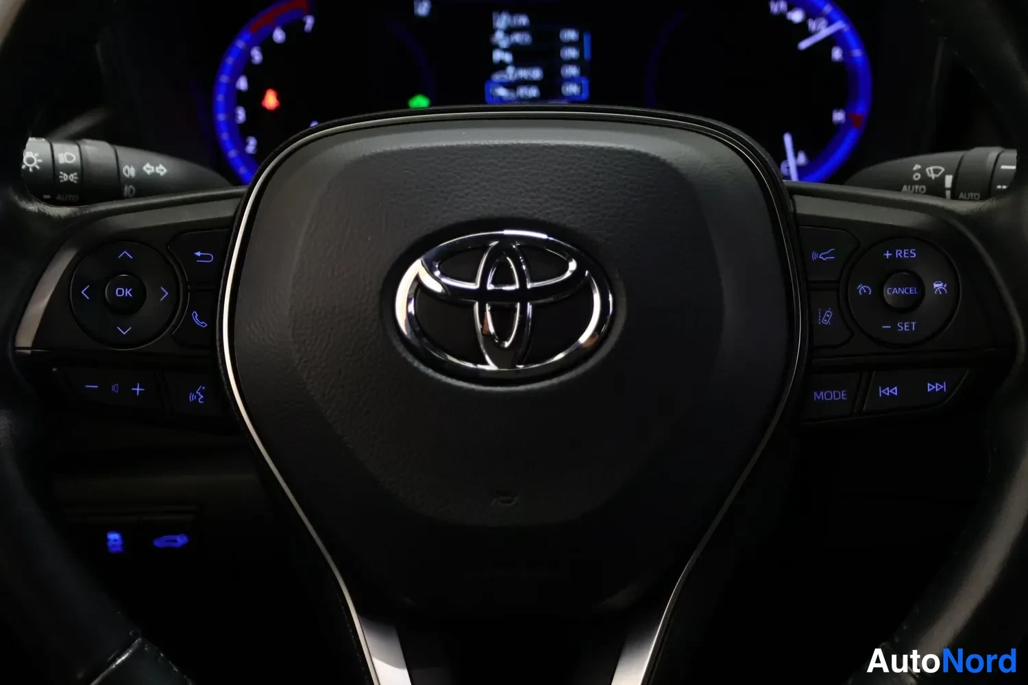 Muu: Toyota-ohjauspyörän keskusta ja ryhmitys: vasemmalla infotainmentin ja puhelun säätimet, oikealla vakionopeudensäädön ja kaiutinpuhelimen painikkeet; mittaristo