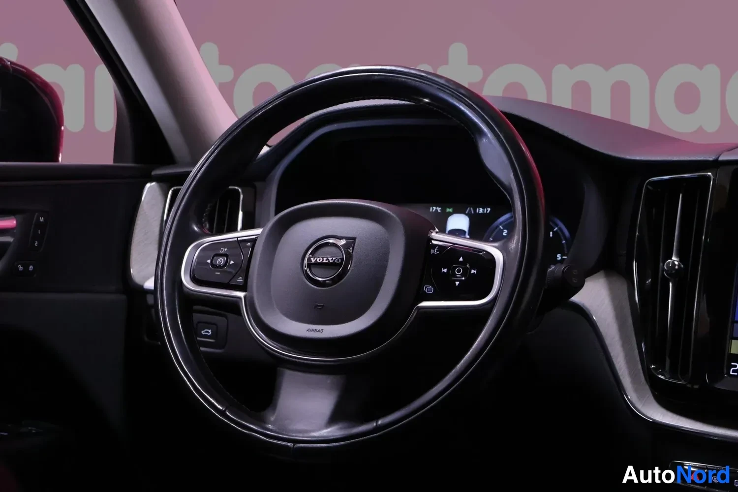 Muu: Ohjaamon näkymä: Volvo-merkkinen ohjauspyörä näppäimistöineen, sen takana osittain näkyvä mittaristo (13:17) sekä kojelaudan ilmastointisuuttimet ja osa keskinä