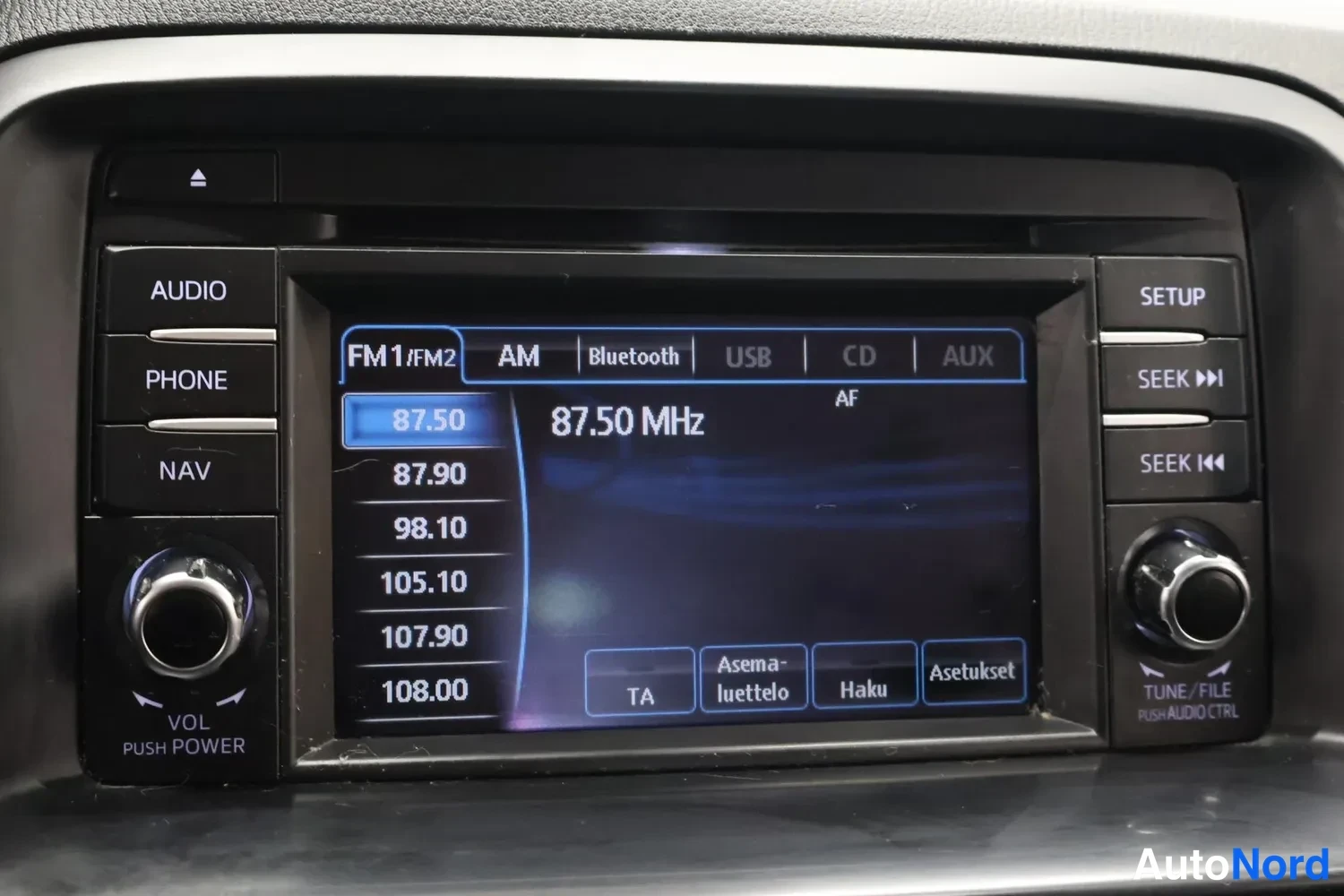 Yksityiskohta: Auton radio- ja multimedialaitteen näyttö FM1-lähetyksellä taajuudella 87,50 MHz, lähdevalikoimassa Bluetooth, USB, CD ja AUX.