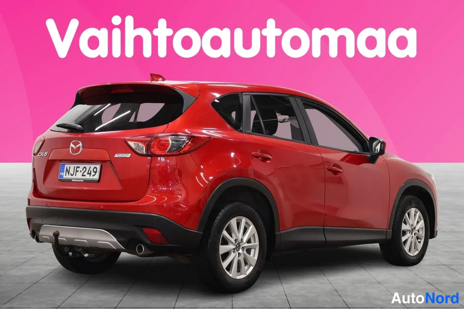 Takaviisto: Punaisen Mazda CX-5:n toinen takakulmanäkyvistä, rekisterikilpi, vetokoukku ja hopeavanteet.