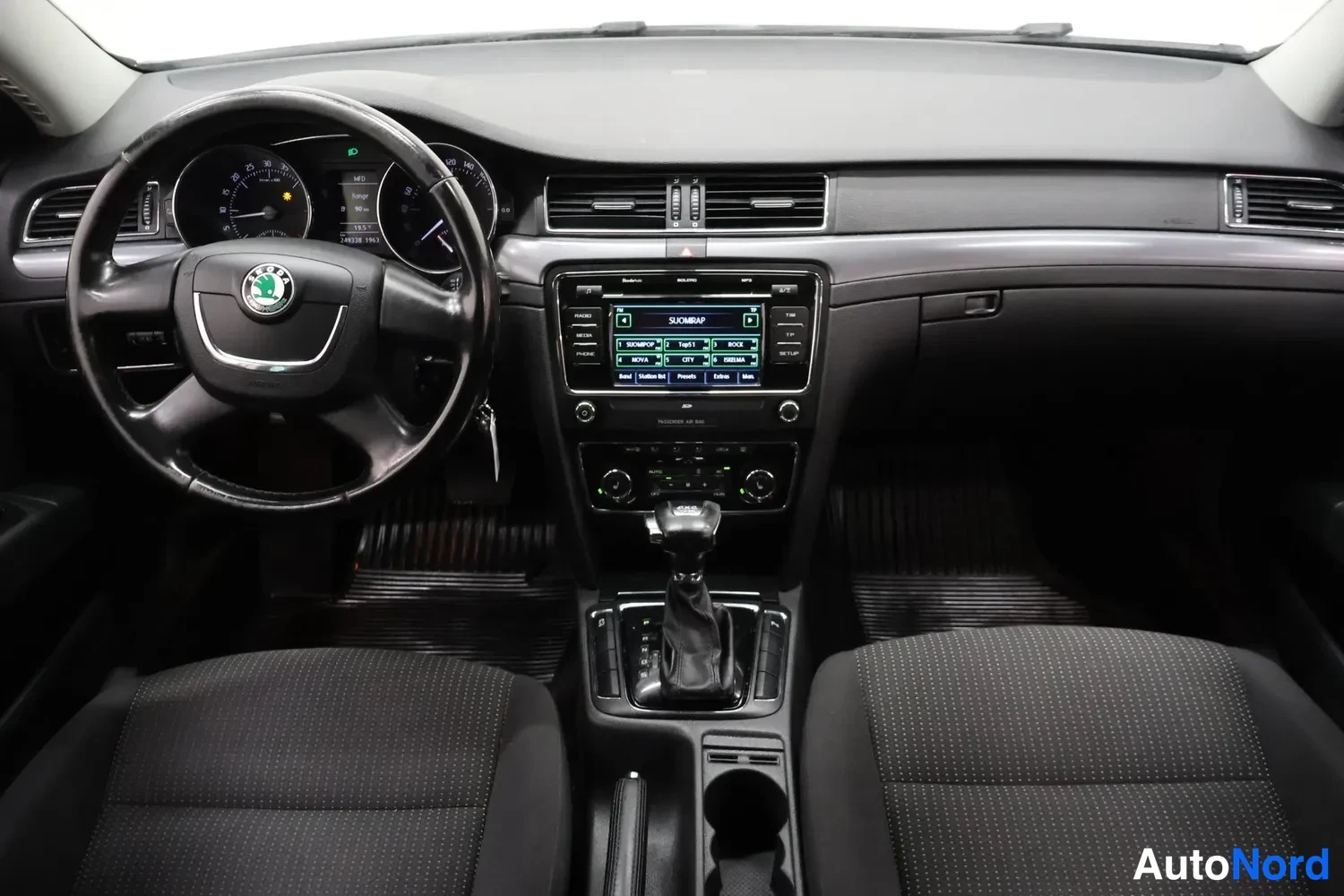 Muu: Kuljettajan näköinen sisänäkymä: Škoda-ohjauspyörä, instrumenttien ja infotainment-näytön osia.