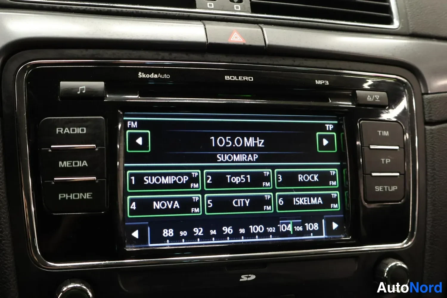 Yksityiskohta: Škoda Auto Bolero -radiolaite näytöllä FM 105.0 MHz Suomirap ja radiokanavavalikko.
