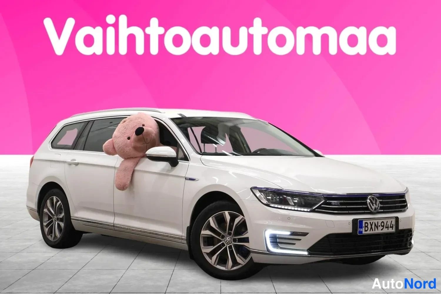 Etuviisto, nokka oikealle: Valkoinen farmariauto kuvattu kolmeneljäsosasta edestä oikealta, rekisterikilpi.