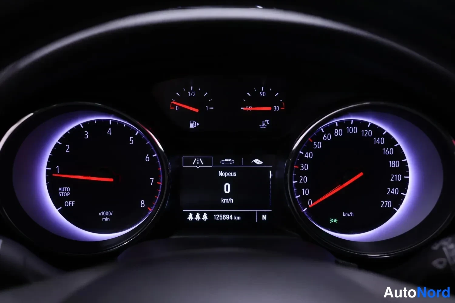 Muu: Kojelaudan mittaristo: nopeusmittari aina 270 km/h asti, matkuri 125694 km ja Nopeus 0 km/h -näyttö.