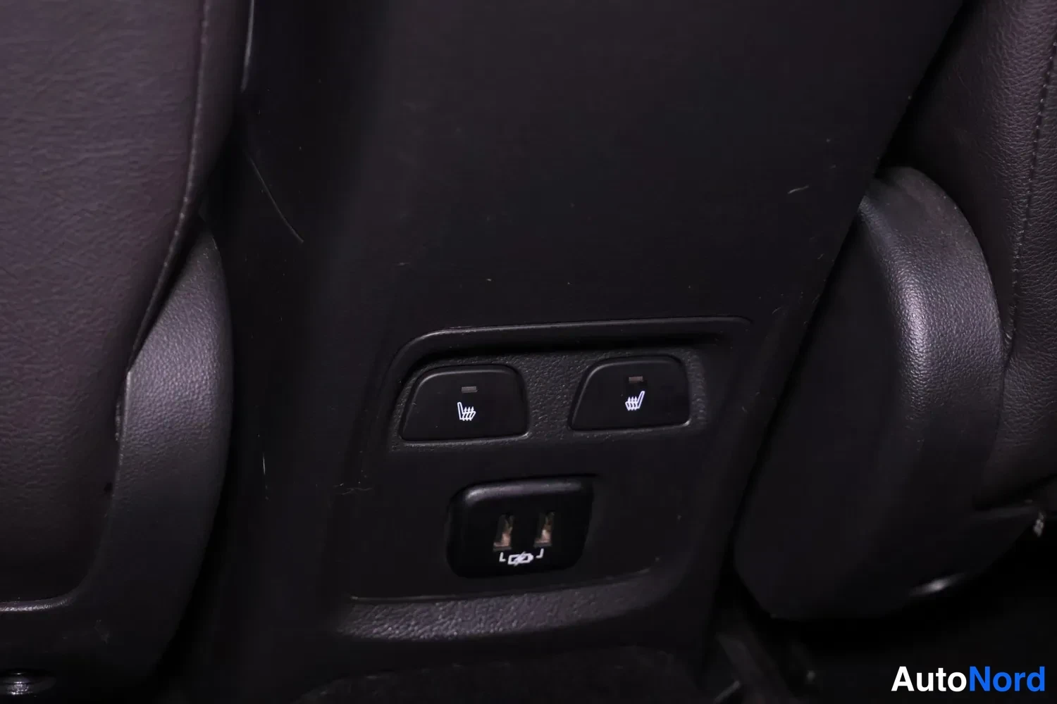 Muu: Takapenkin vieressä oleva paneeli, jossa on kaksi lämmityspainiketta ja kaksi USB-porttia.