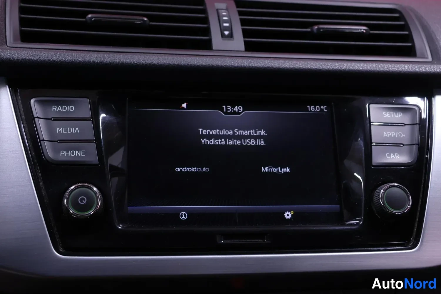 Muu: Autojen kojelaudan keskikonsoli: kosketusnäyttö näyttää tekstin 'Tervetuloa SmartLink. Yhdistä laite USB:llä.' sekä android auto- ja MirrorLink-logot, ympärillä