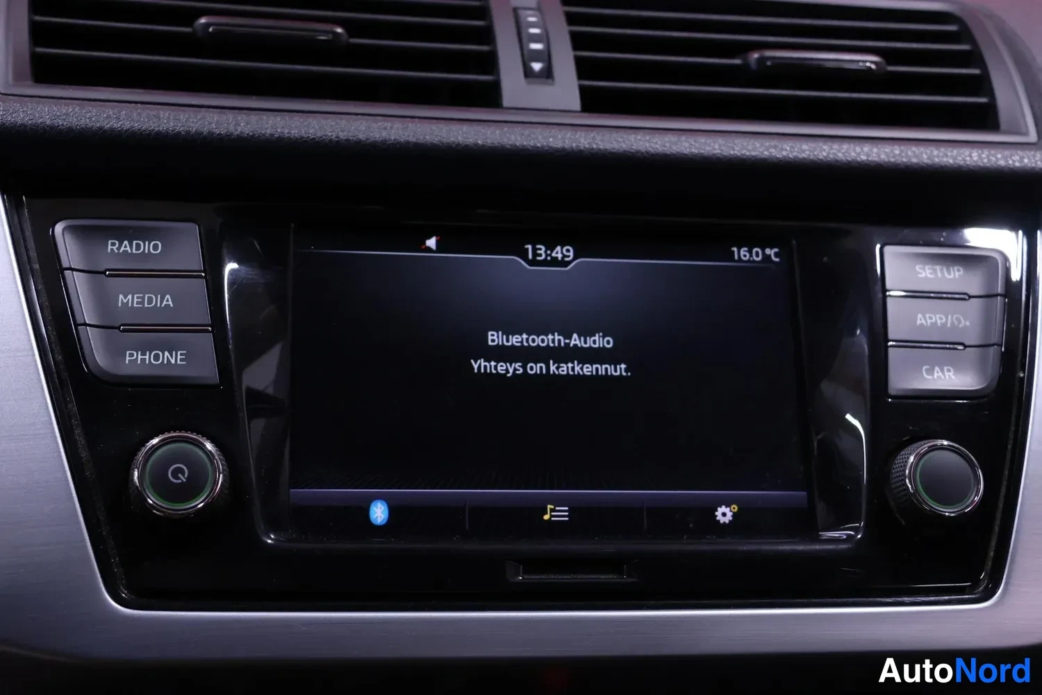 Muu: Keskikonsolin radio: näyttö näyttää tekstin 'Bluetooth-Audio Yhteys on katkennut.', kellonajan 13:49 ja lämpötilan 16,0 °C, ympärillä RADIO-, MEDIA-, PHONE-, SE