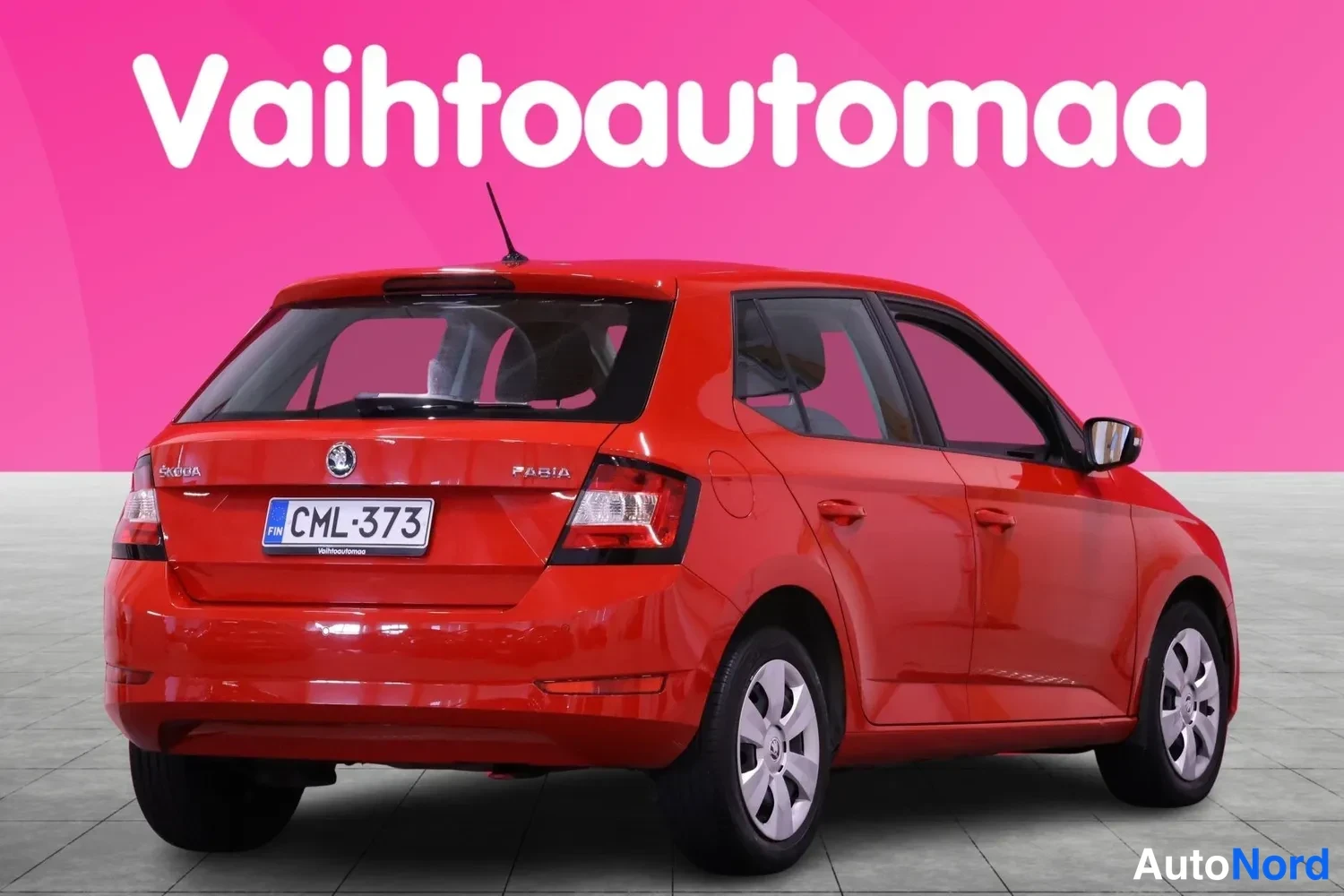 Takaviisto: Punaisen hatchback-auton takakulma, takavalojen, takaluukun ja kyljen näkyessä, rekisteritunnus.
