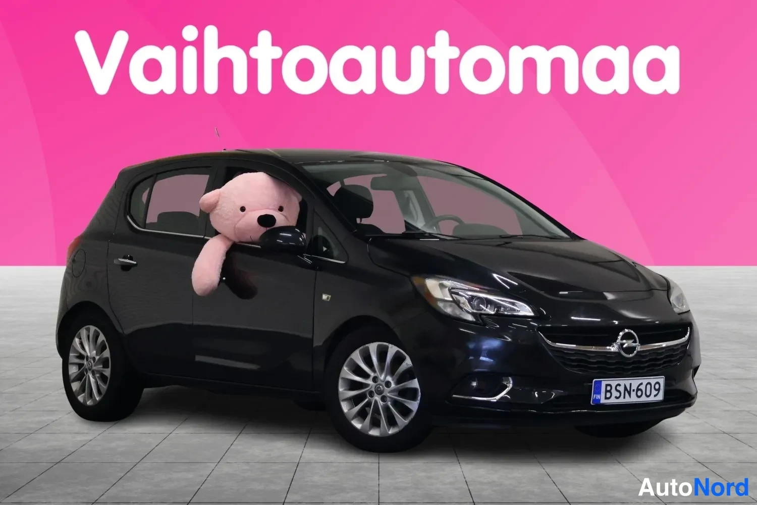 Etuviisto, nokka oikealle: Musta hatchback etuviistossa oikealta, rekisterikilpi, kuvattu pinkissä studiossa.