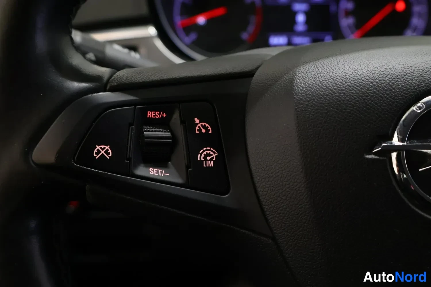 Muu: Ohjauspyörän vasemman puolen painikkeet: RES/+, SET/–, LIM ja rajoitinpoisto, Opel-embleemi oikealla.