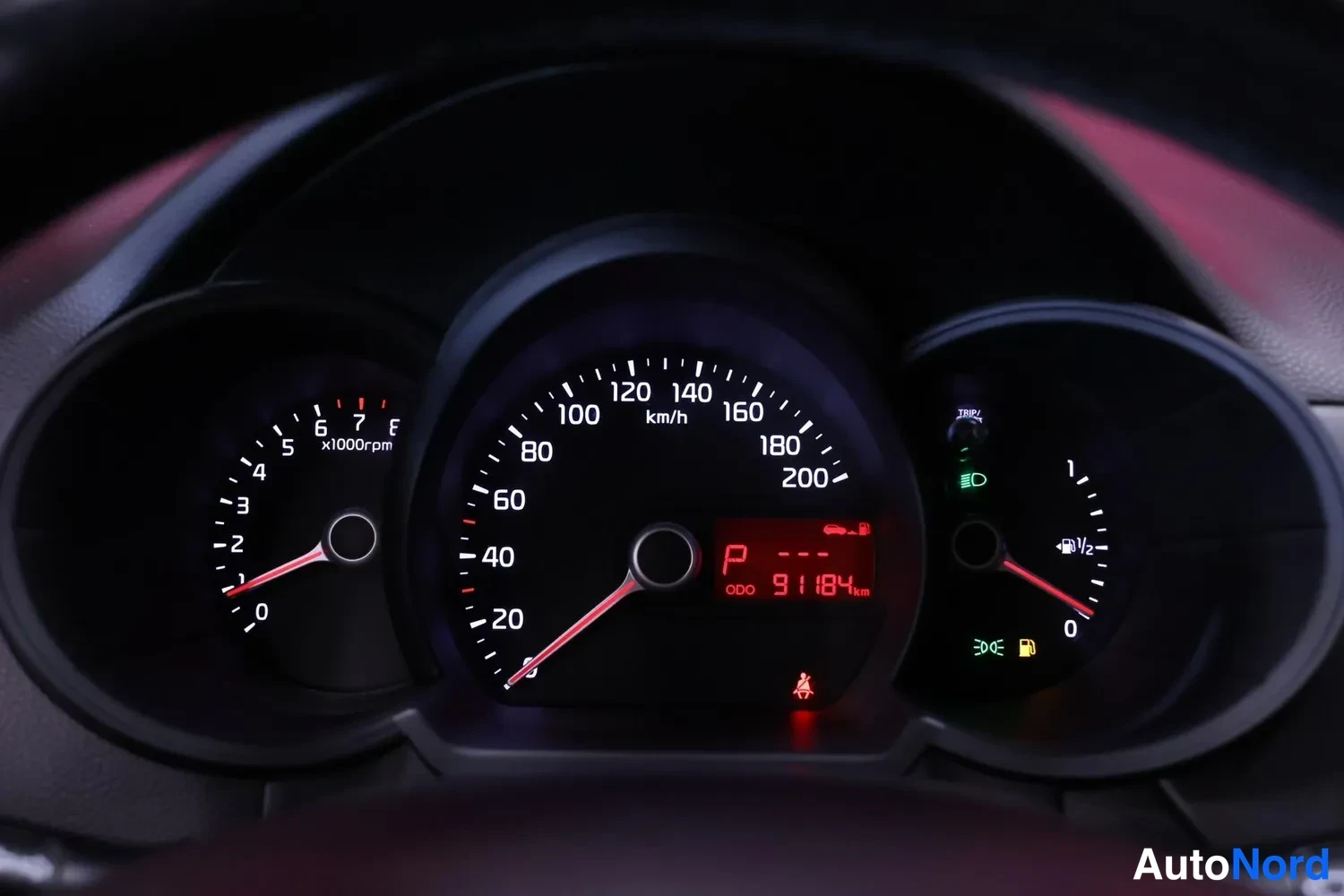 Muu: Kojelaudan mittaristo: nopeusmittari 0-200 km/h, kierrosmittari ja polttoainemittari; näytössä P ja lukema ODO 91184 km.
